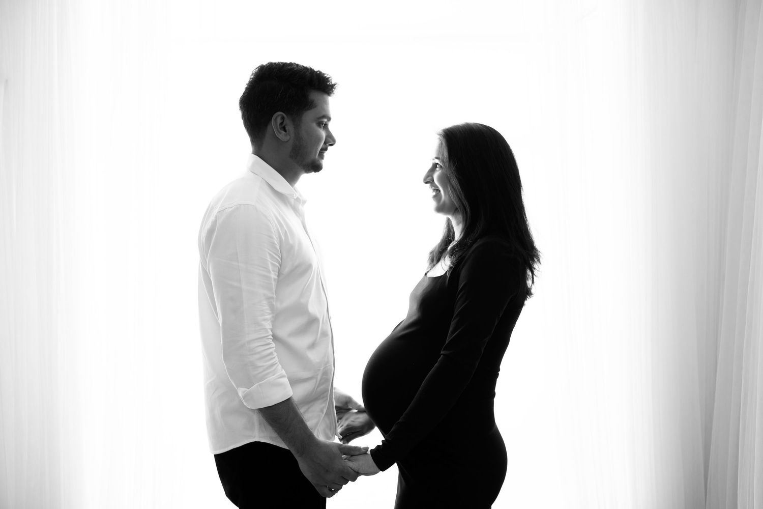 Pregnant woman holding hands with partner by Little Wonderland Phography widnes cheshire