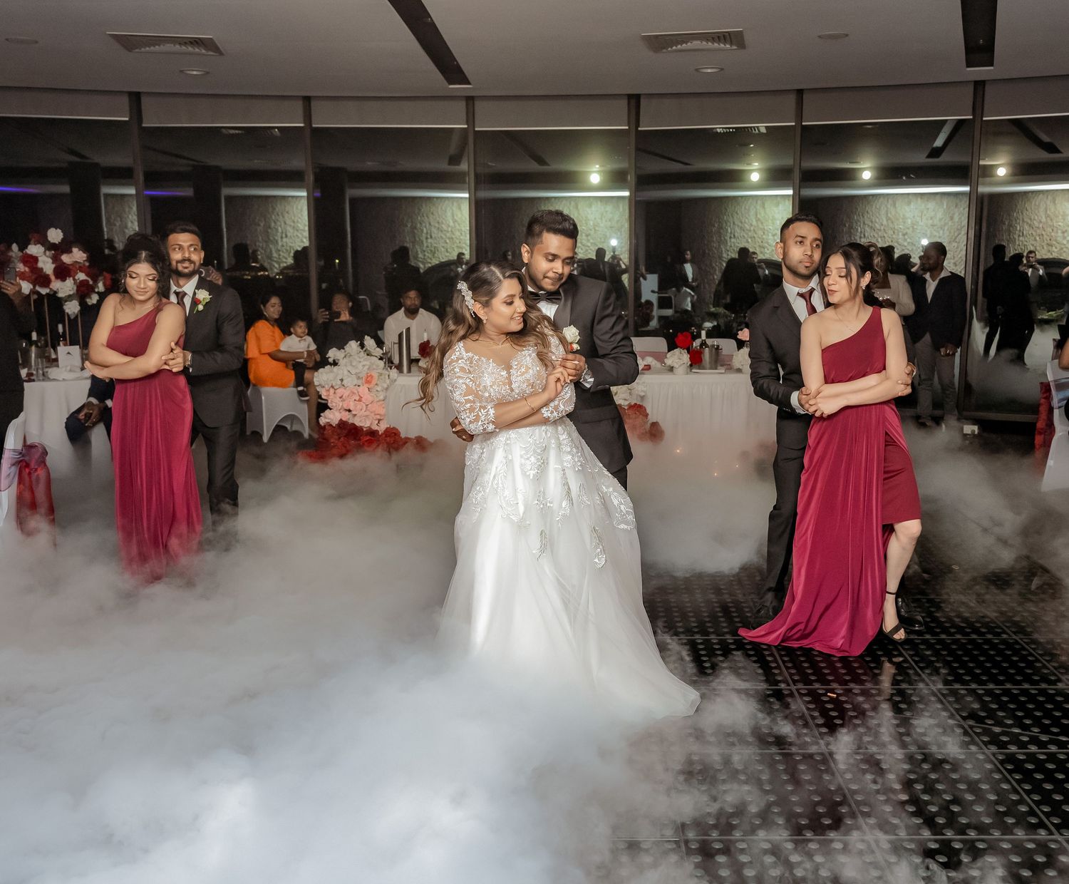 Dancers move gracefully across a fog-covered dance floor during an elegant wedding reception celebration.