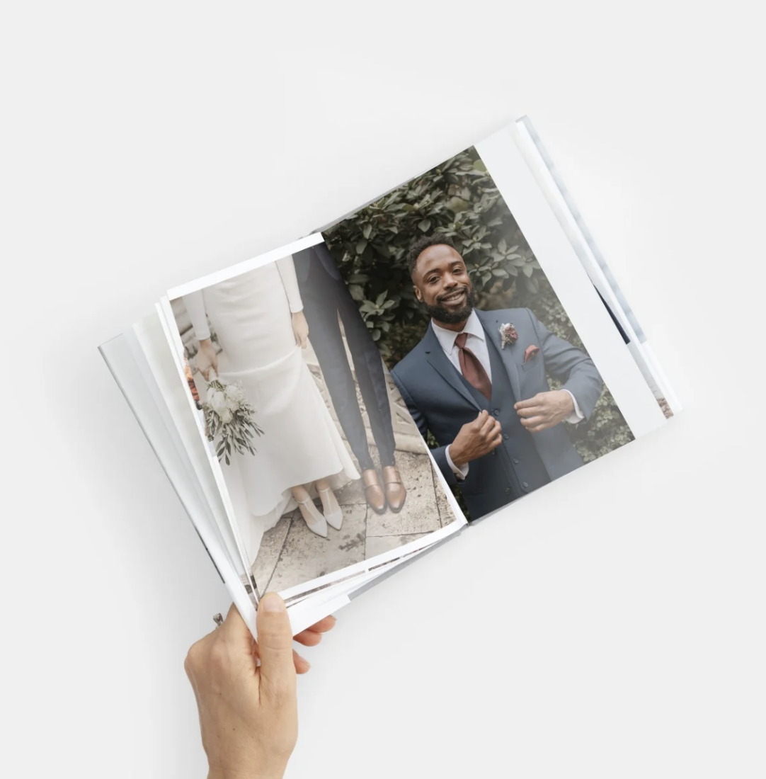 Close up shot of hands holding and arranging white printed photograph prints.