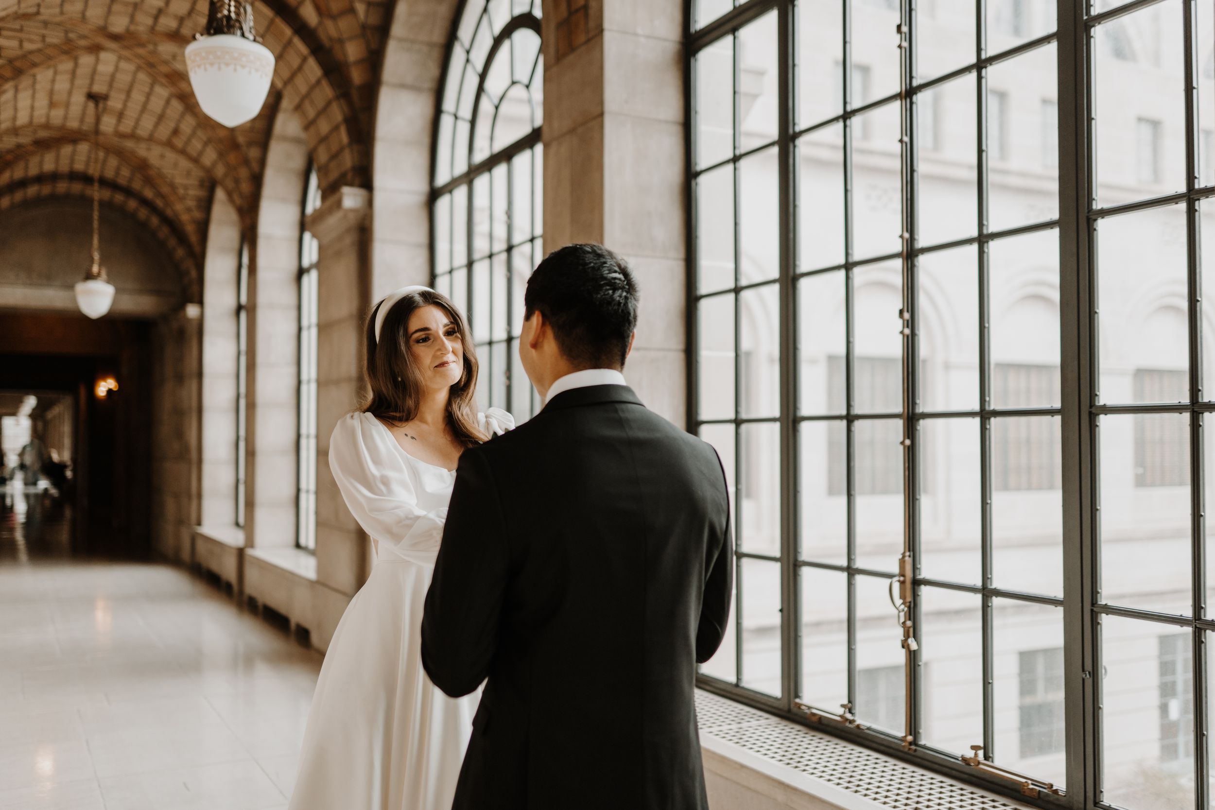Elegant wedding venue with dramatic arch windows and natural light streaming in.