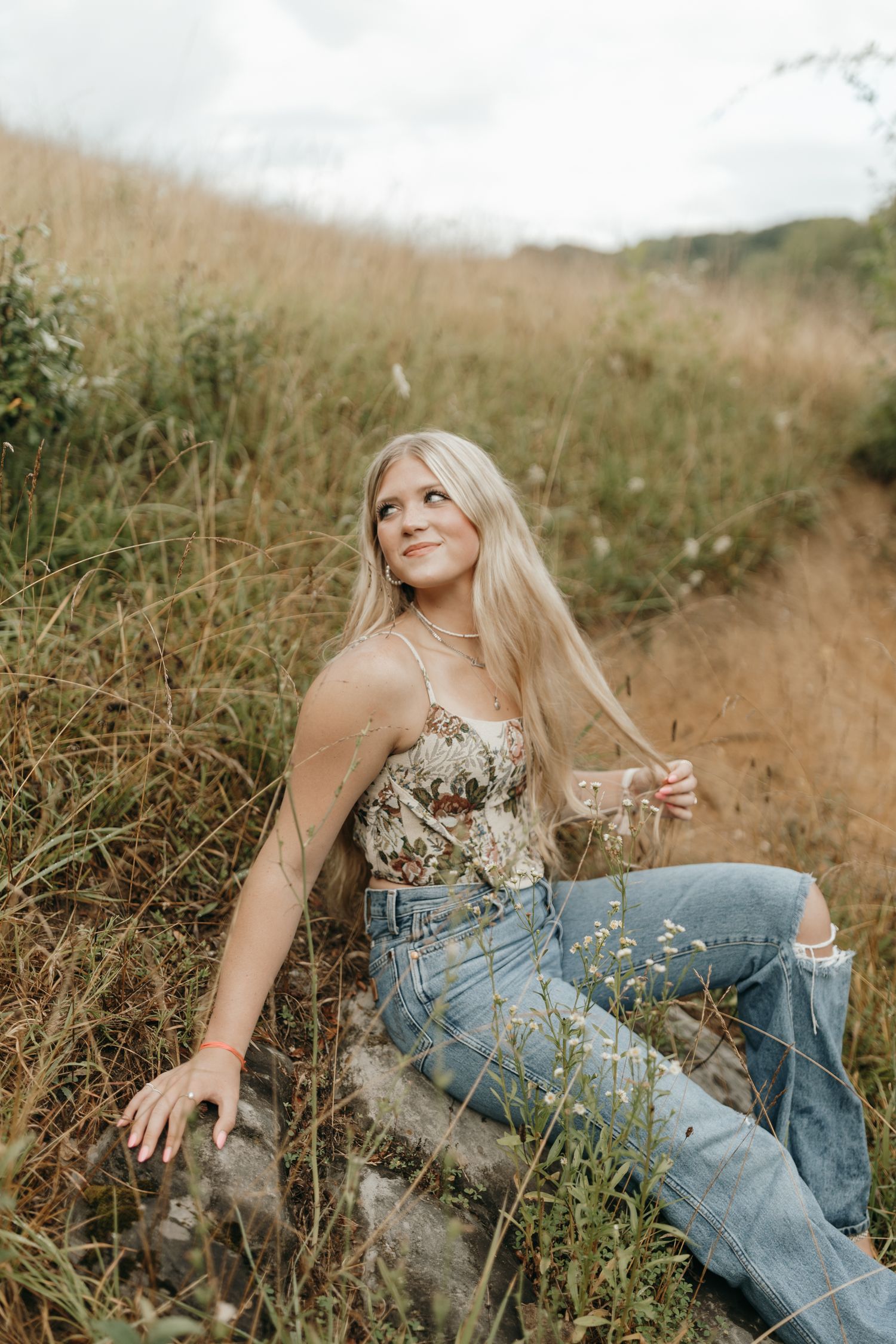 Boho portrait in tall grass field with soft natural lighting.