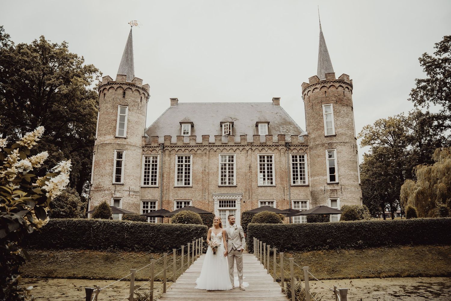 Elegant château wedding venue with twin spires and a grand entrance walkway.