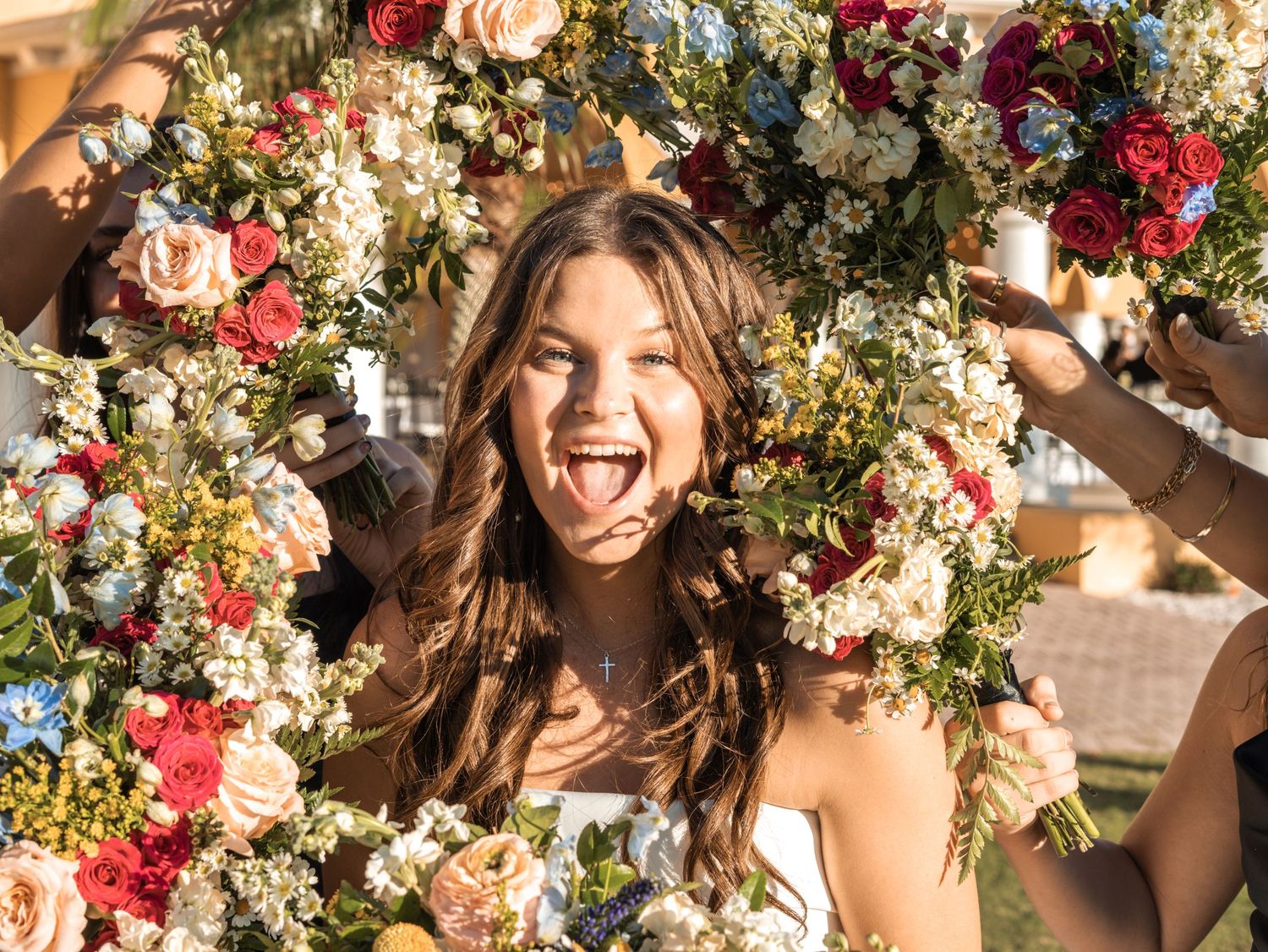 Joyful portrait through a floral frame with pink and red blooms.