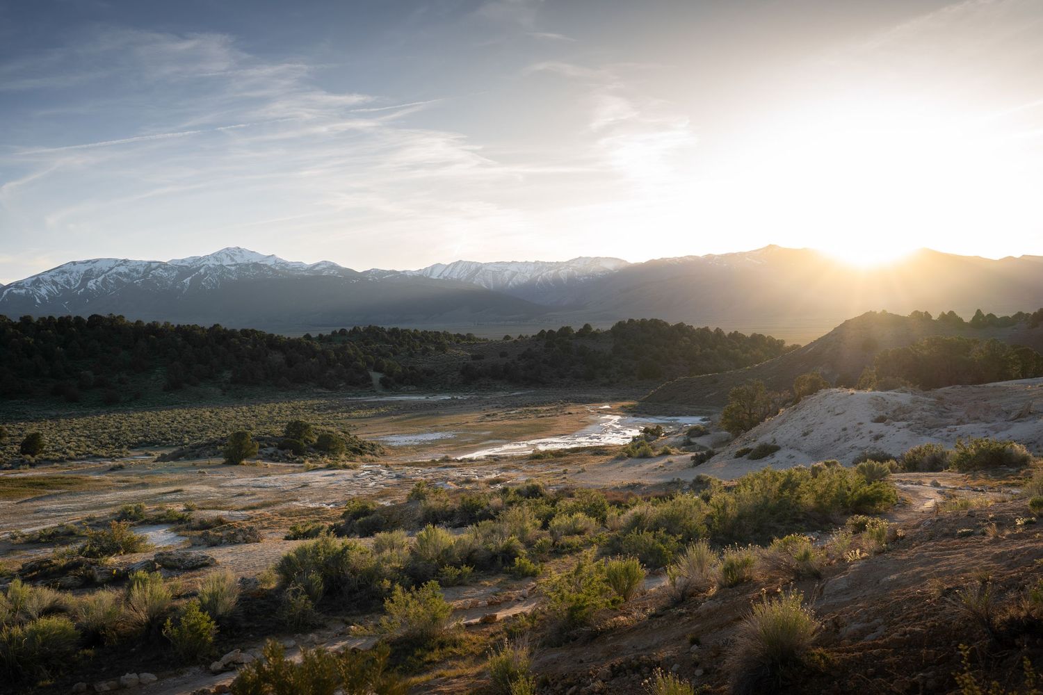 Sunset over a snowy mountain range at Travertine Hot Springs, near Bridgeport, California.