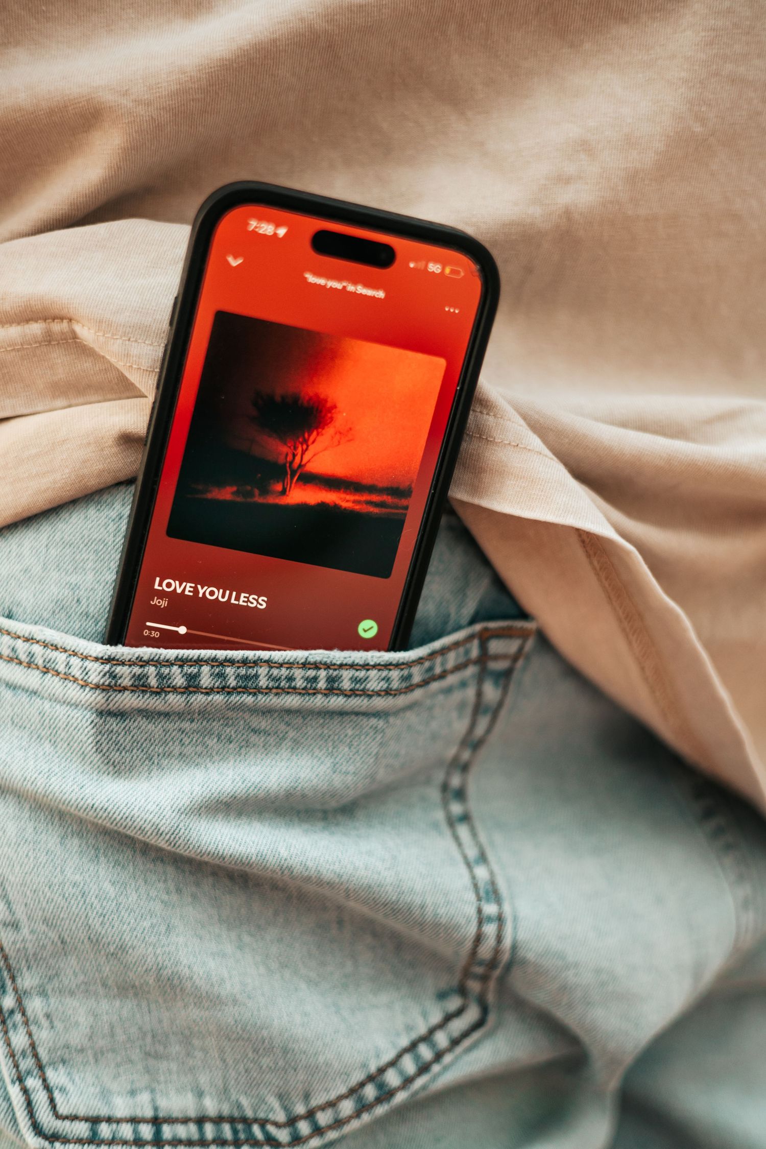 Smartphone in jeans pocket playing Love You Less on Spotify with red album art | Couple Photos in Boulder, Colorado