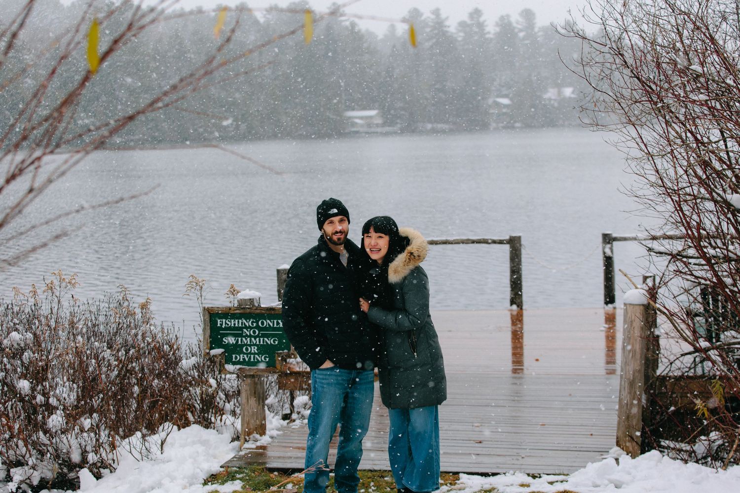 People stand near a flooded road sign during severe winter weather conditions in the Pacific Northwest.