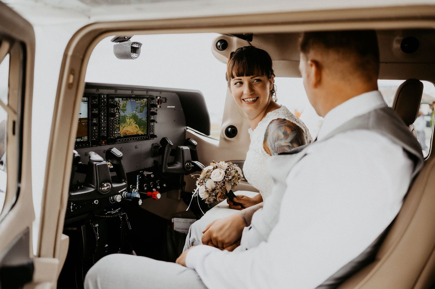 Pilot and passenger in cockpit of small aircraft preparing for flight.
