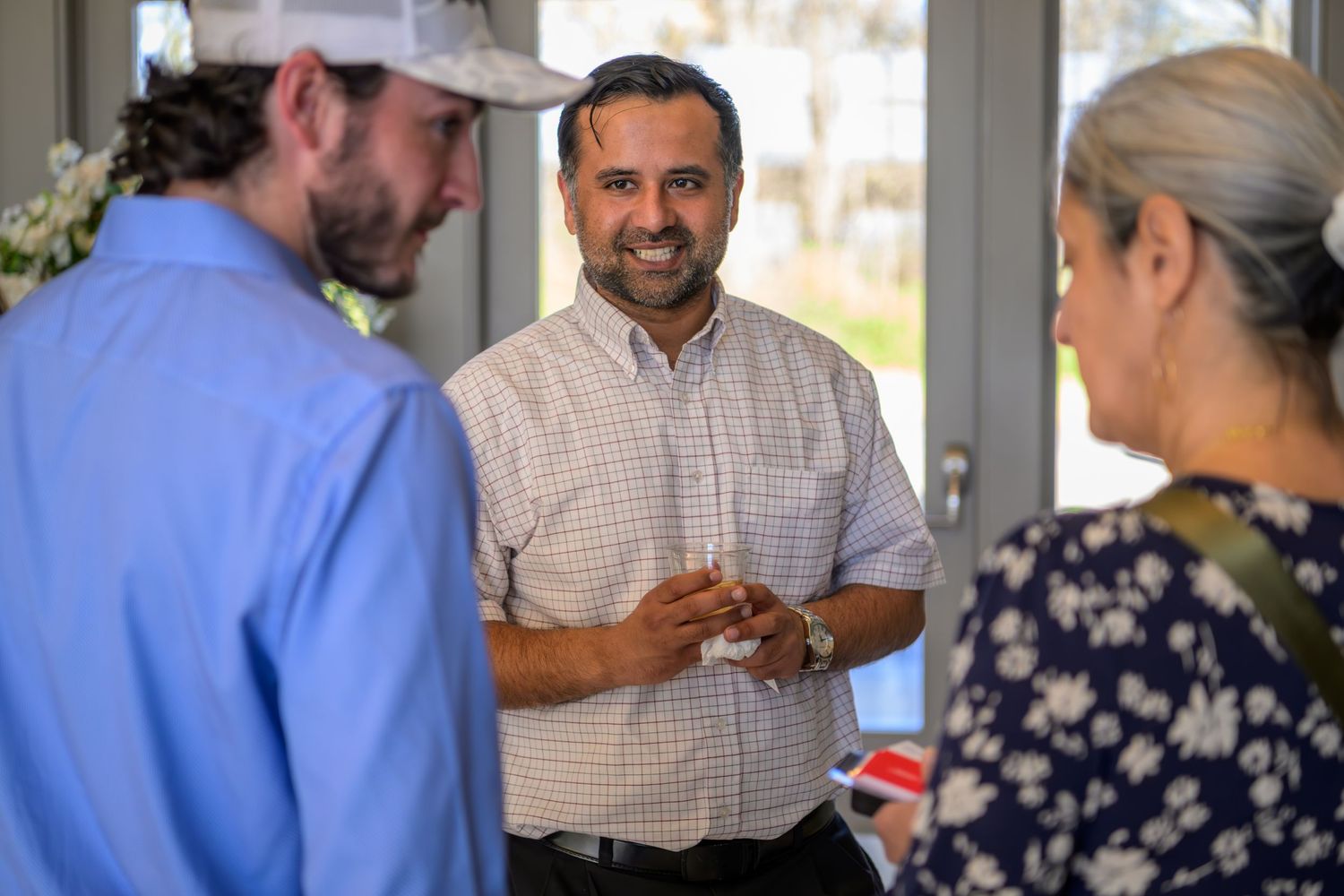 Healthcare providers discuss patient care and review medical charts in a busy hospital hallway setting.