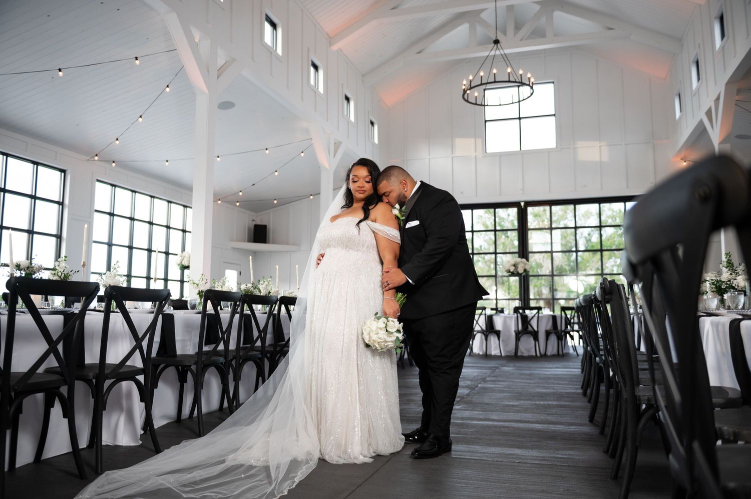 The groom kisses the shoulder of his new wife at the Scars Farm, captured by Palm Beach wedding photographers.