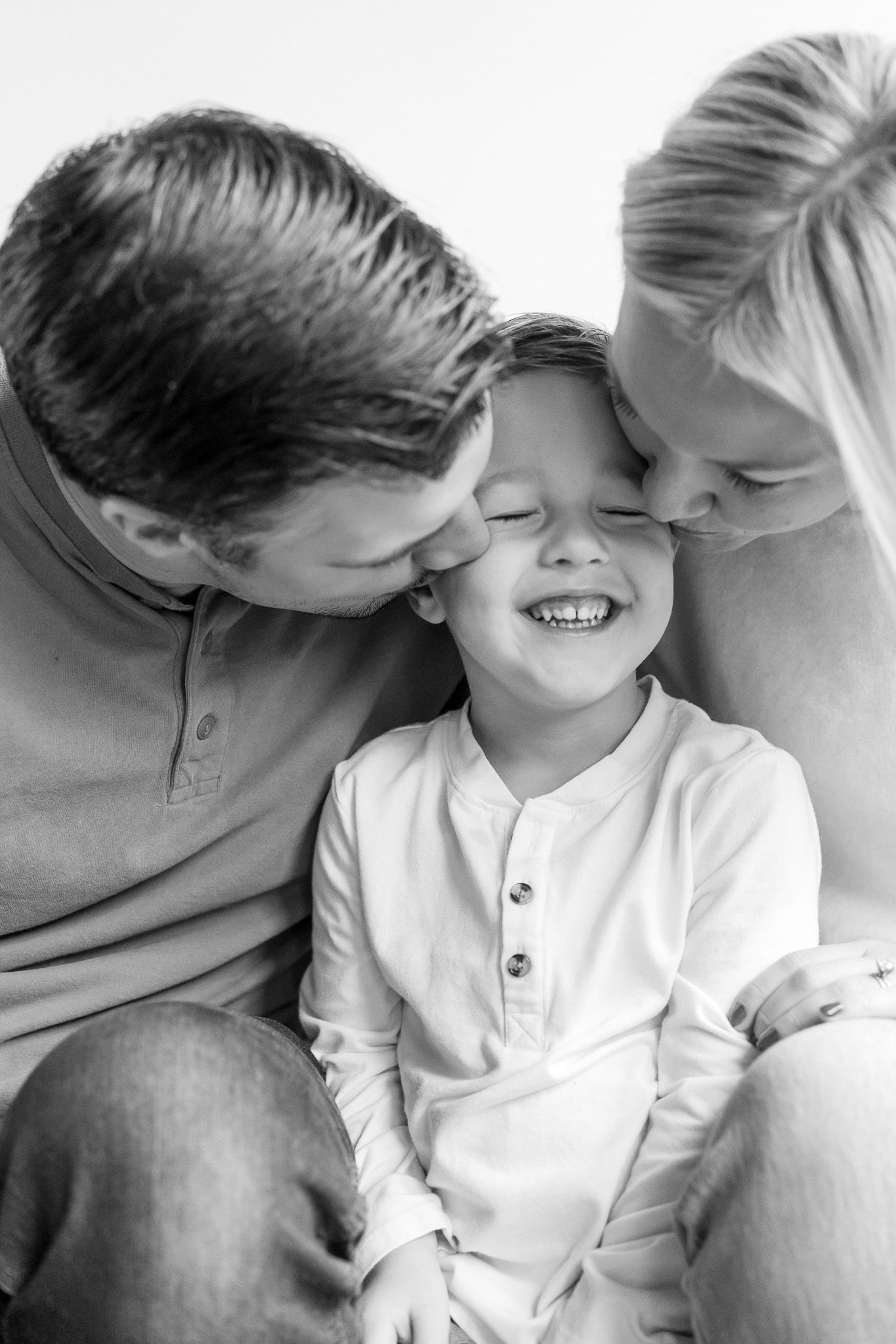 A tender black and white photo series showing intimate family moments of affection and laughter.
