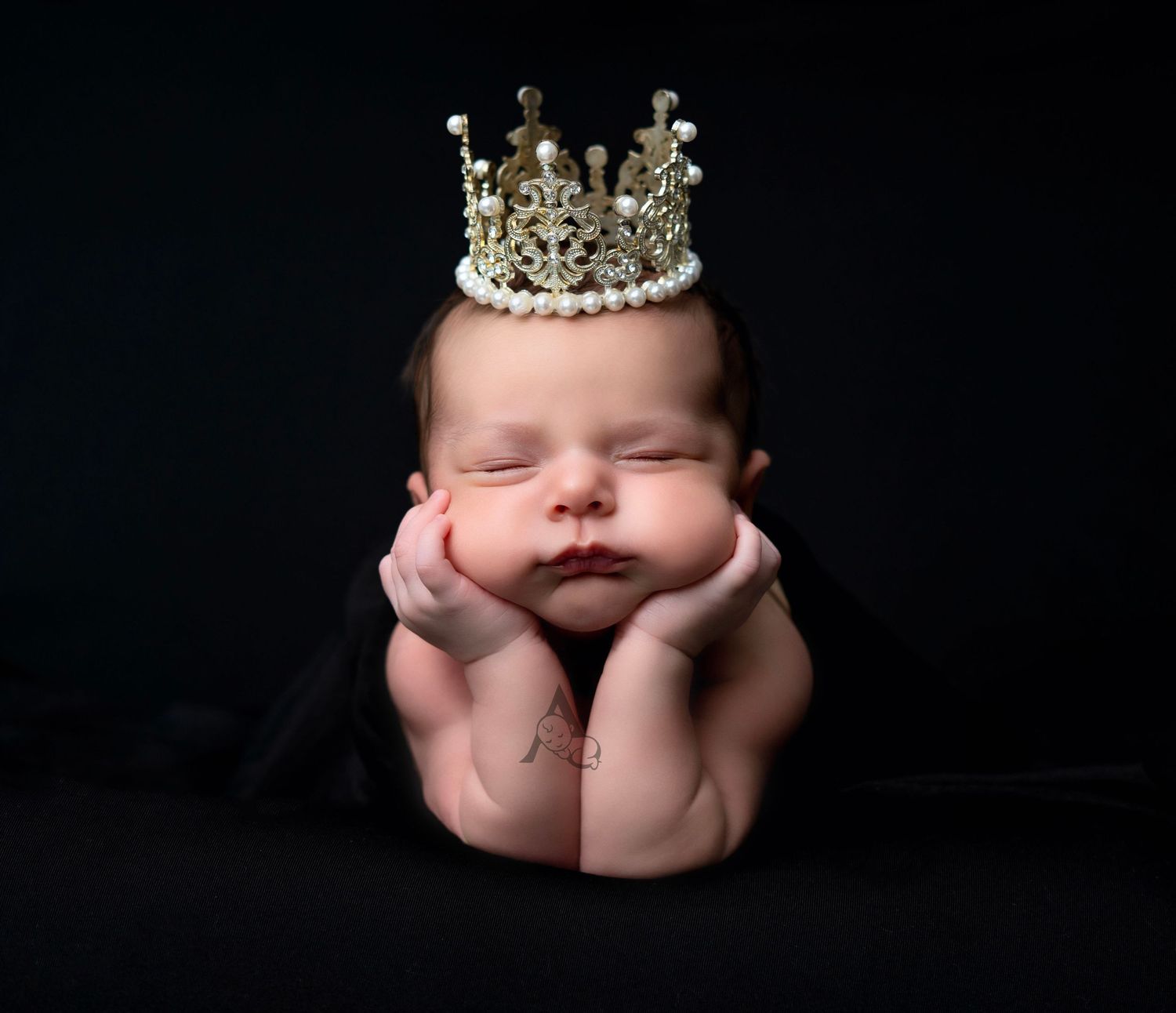 A series of artistic newborn baby photos showing tiny feet, hands, and a delicate crown against a dark background.