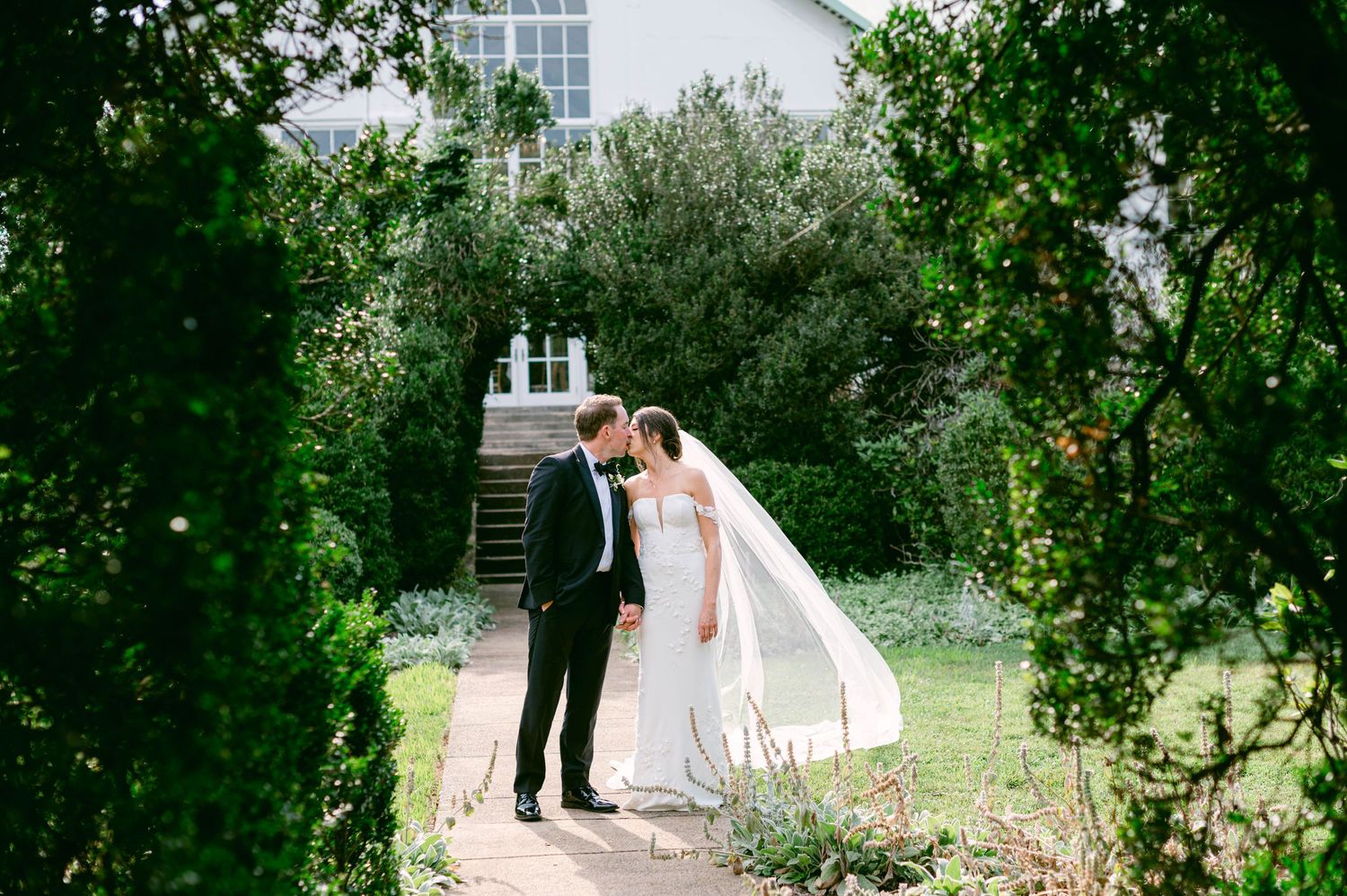Just married couple embracing at elegant wedding venue with period artwork and windows at the DAR Constitution Hall in Washington DC.