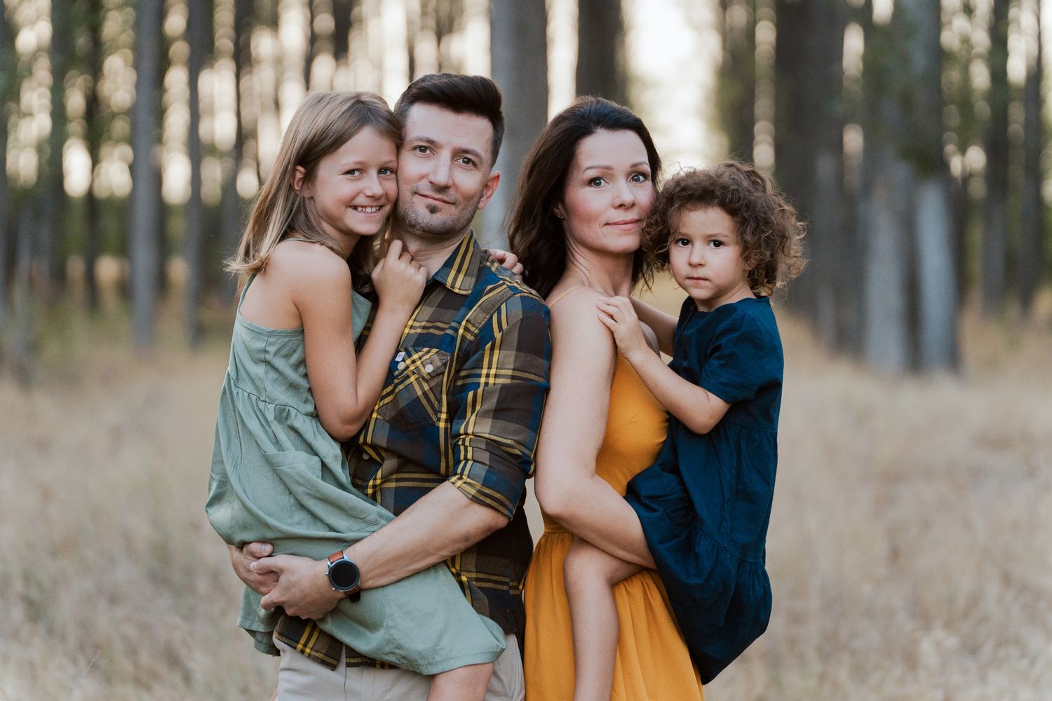 Loving family enjoys intimate outdoor photo session in a golden field of Western Sydney Parklands