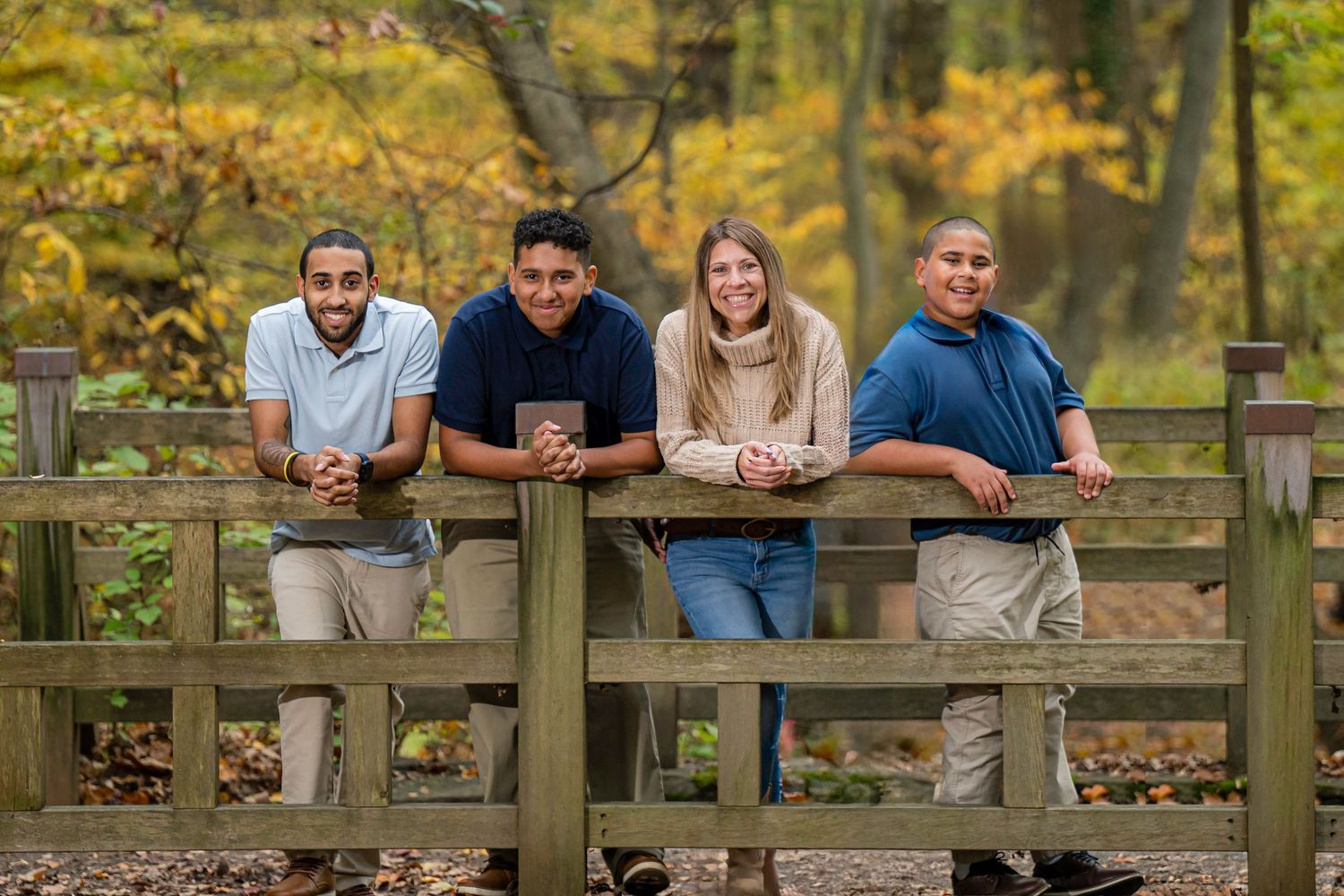 Family enjoying a fall portrait session surrounded by colorful autumn foliage in Fairfield, Connecticut