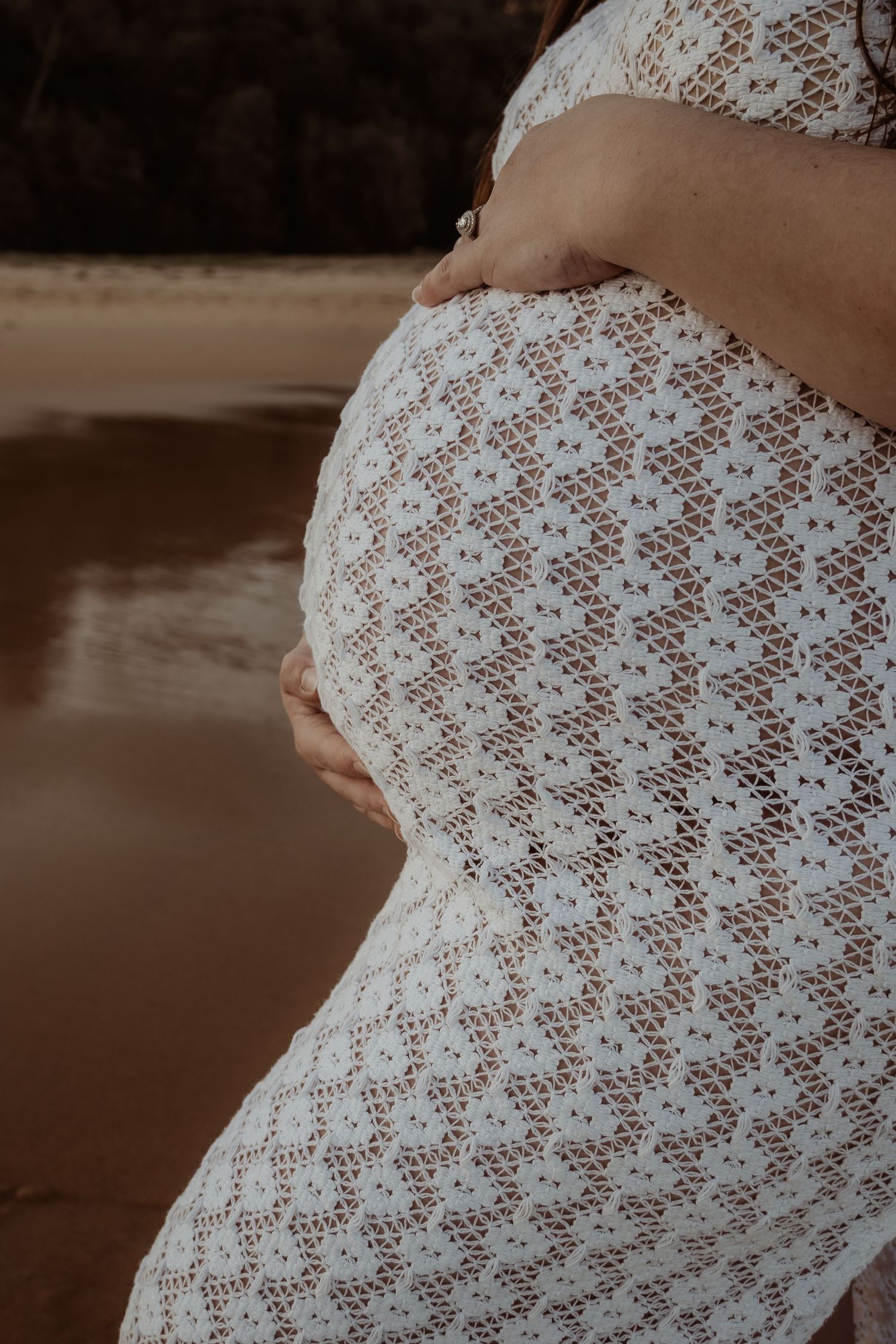 A series of close-up photos showing a pregnant belly covered in delicate white lace fabric against a sepia background.