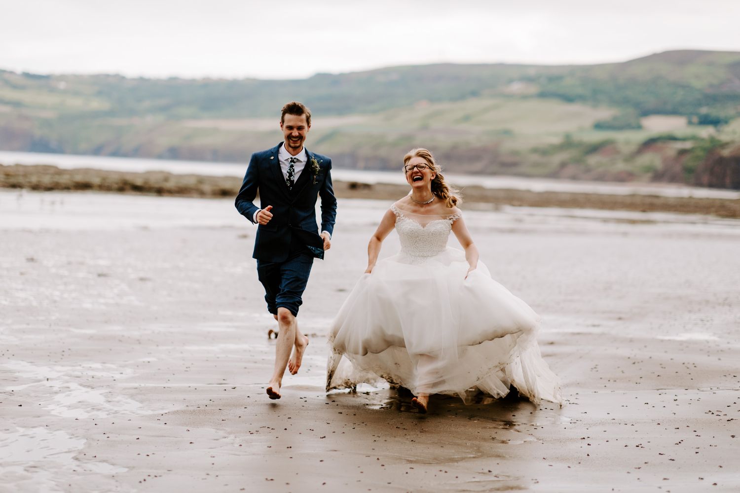Wedding couple running on North Yorkshire Beach