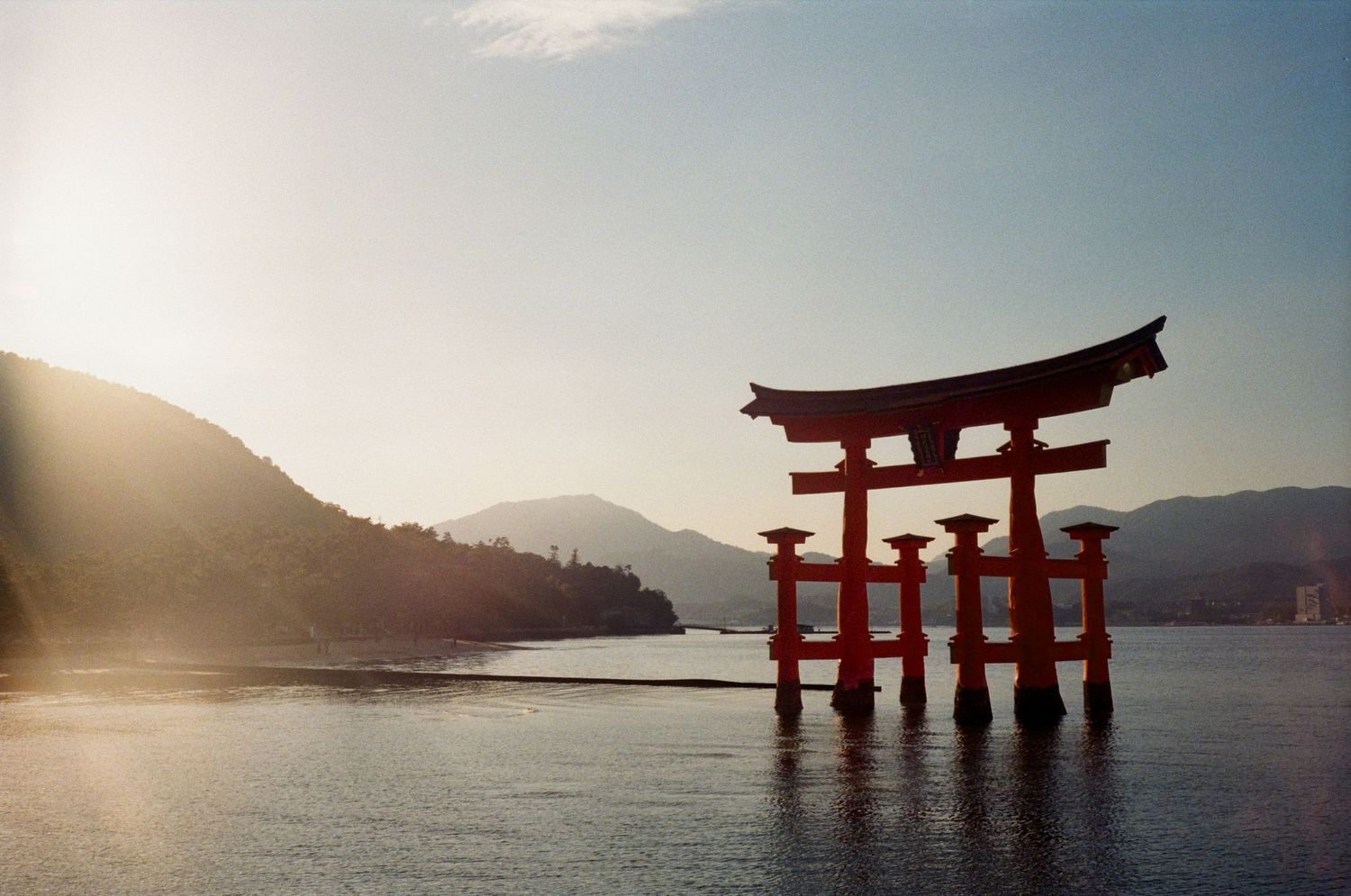 Seven black and white photos of the famous Itsukushima floating torii gate in Miyajima, Japan during different tides.