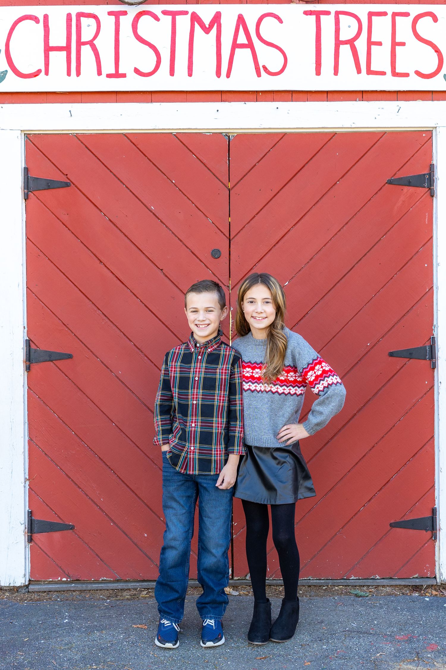 Progressive series of photos showing two children in plaid shirts and jeans posing against a large red barn door.