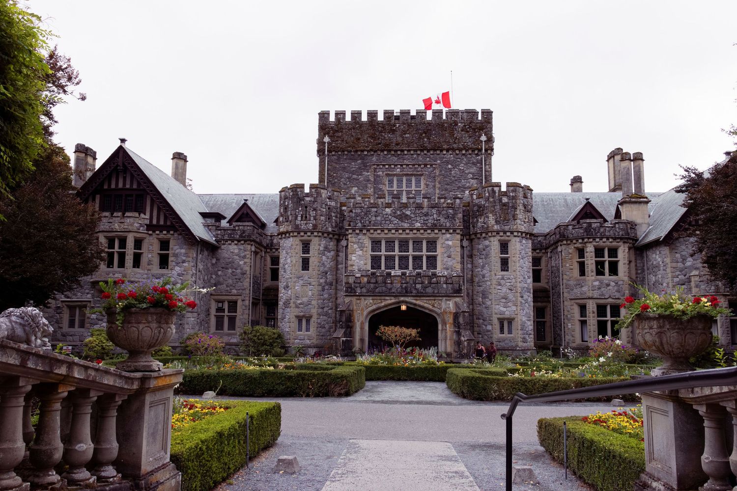 Stone castle mansion with Tudor-style architecture and manicured gardens viewed from multiple angles.