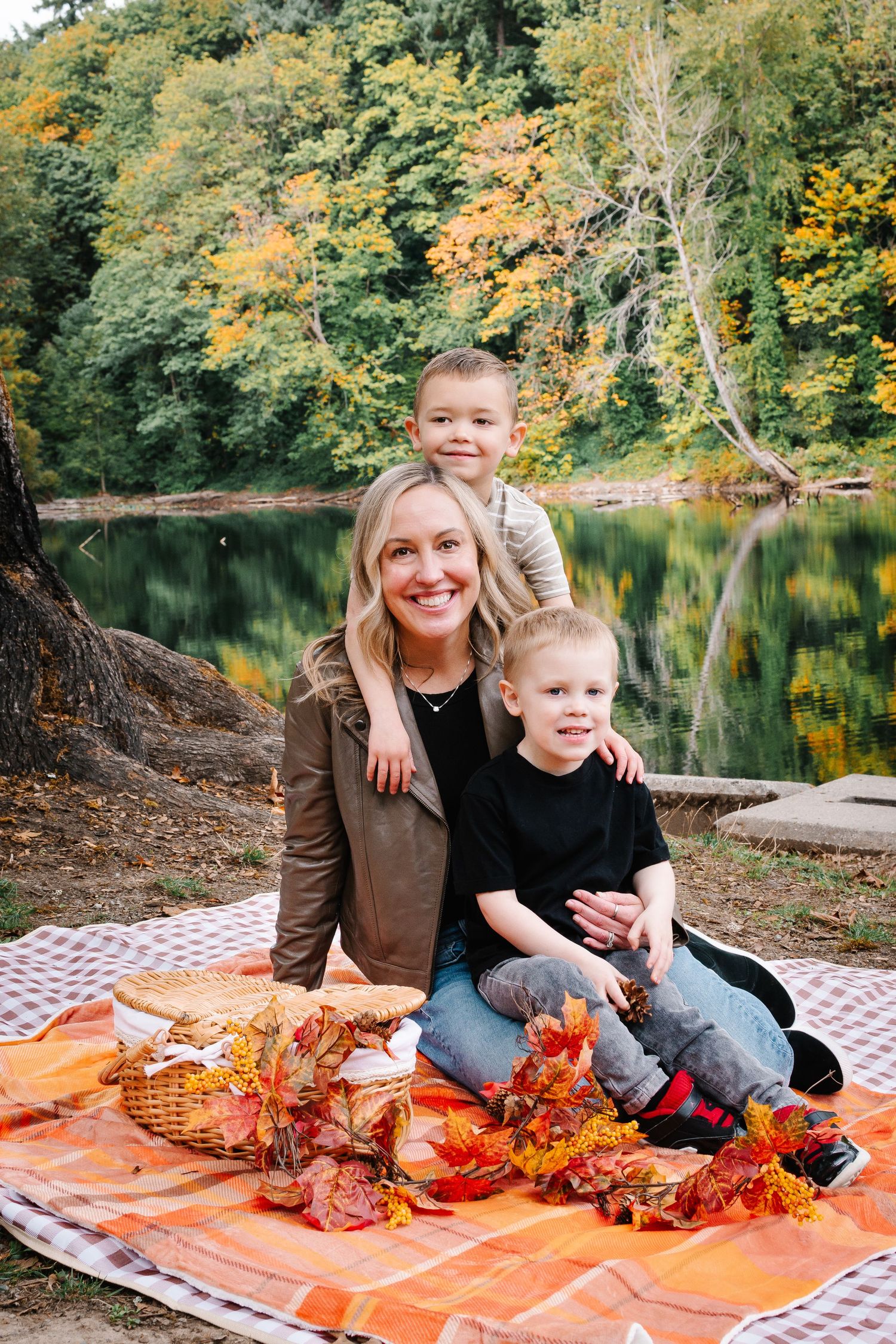 Family sitting by the lake during fall golden hour at Lake Fenwick Park in Kent, WA.