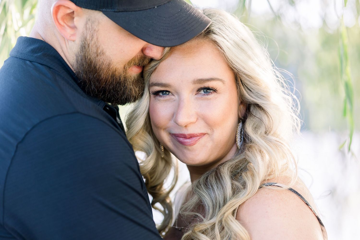 Intimate couple portraits with willow trees and water in background.