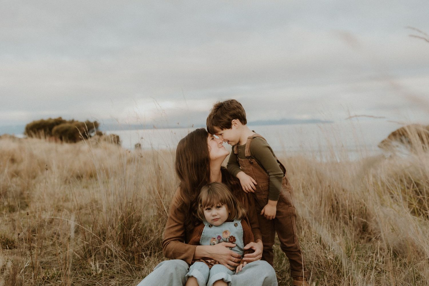 Family sharing an intimate moment together in a golden field.