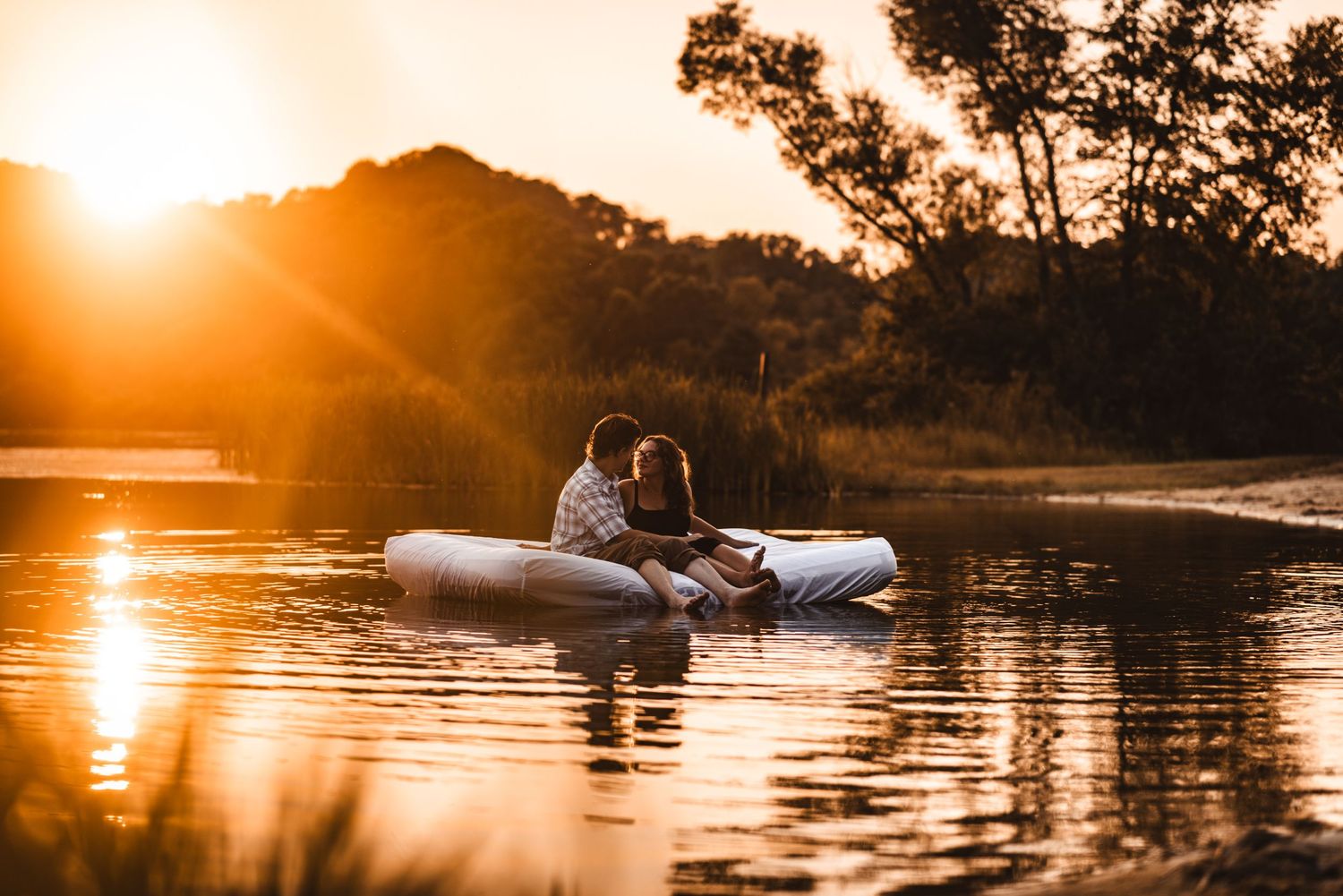 A romantic sunset boat ride on calm waters with golden light reflecting off the surface.