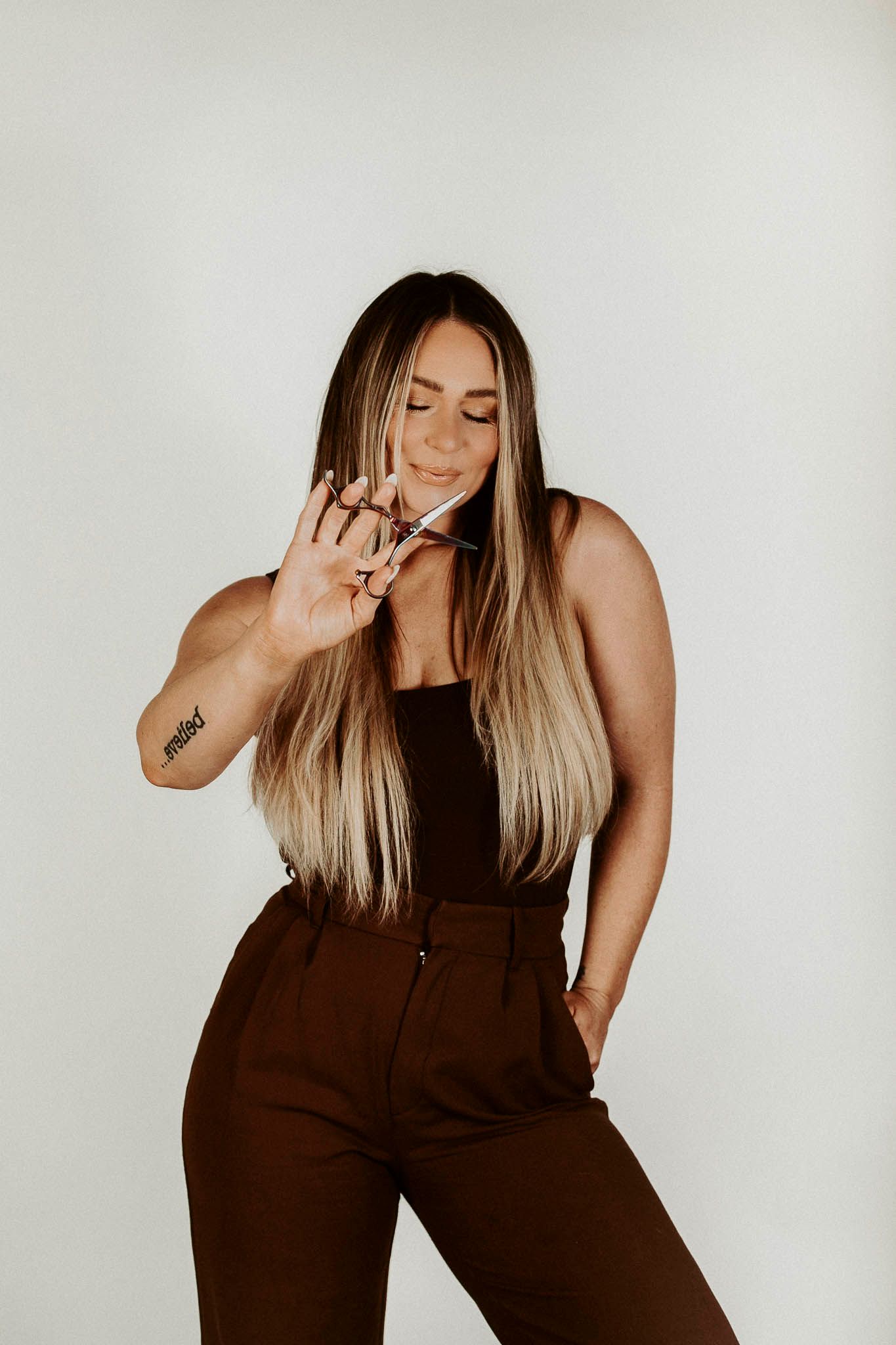 Person in a brown monochrome outfit strikes a casual pose against a white background.