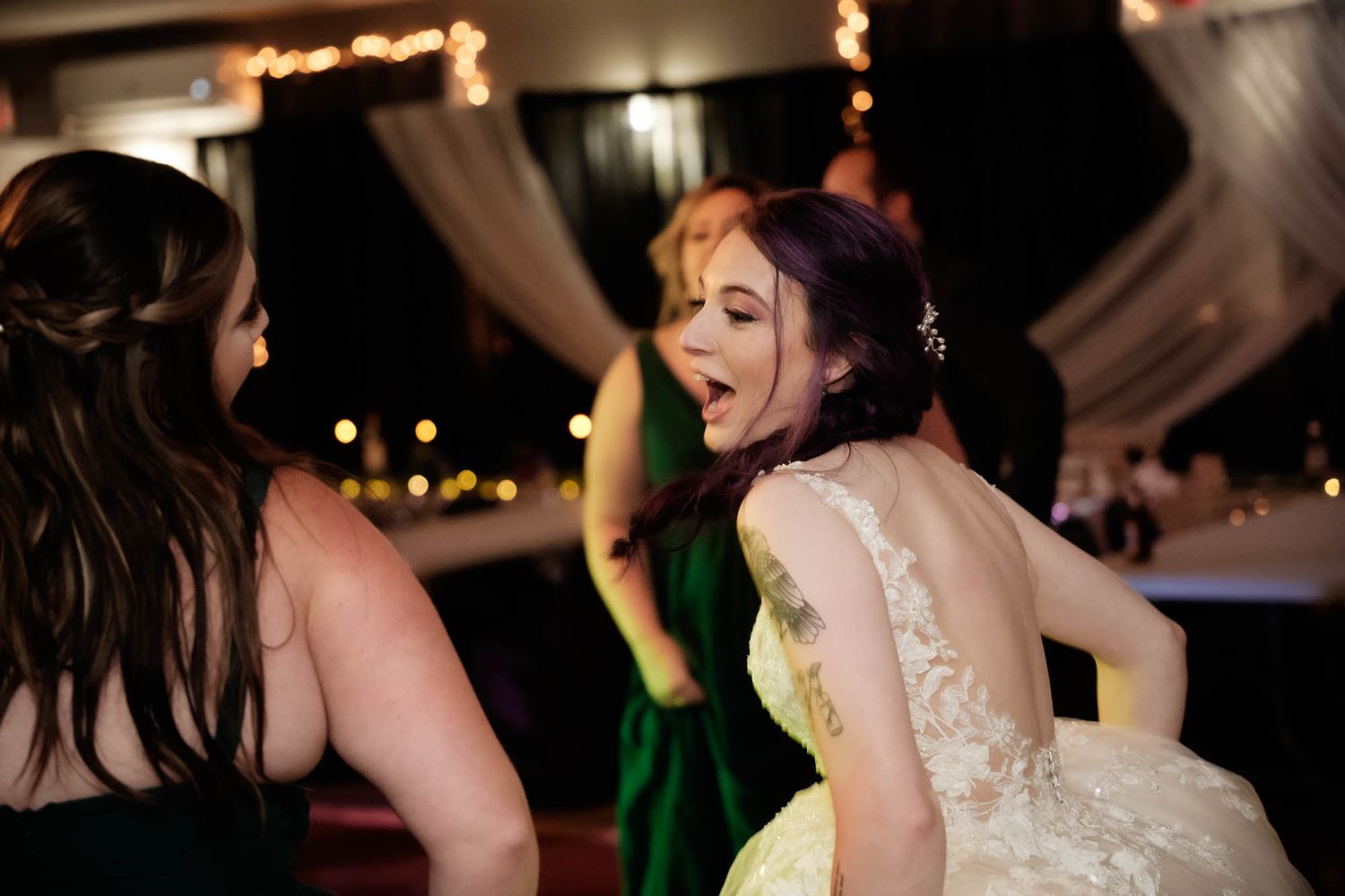 Bride dancing at the reception with mixed dancing lights, captured by the best wedding photographer