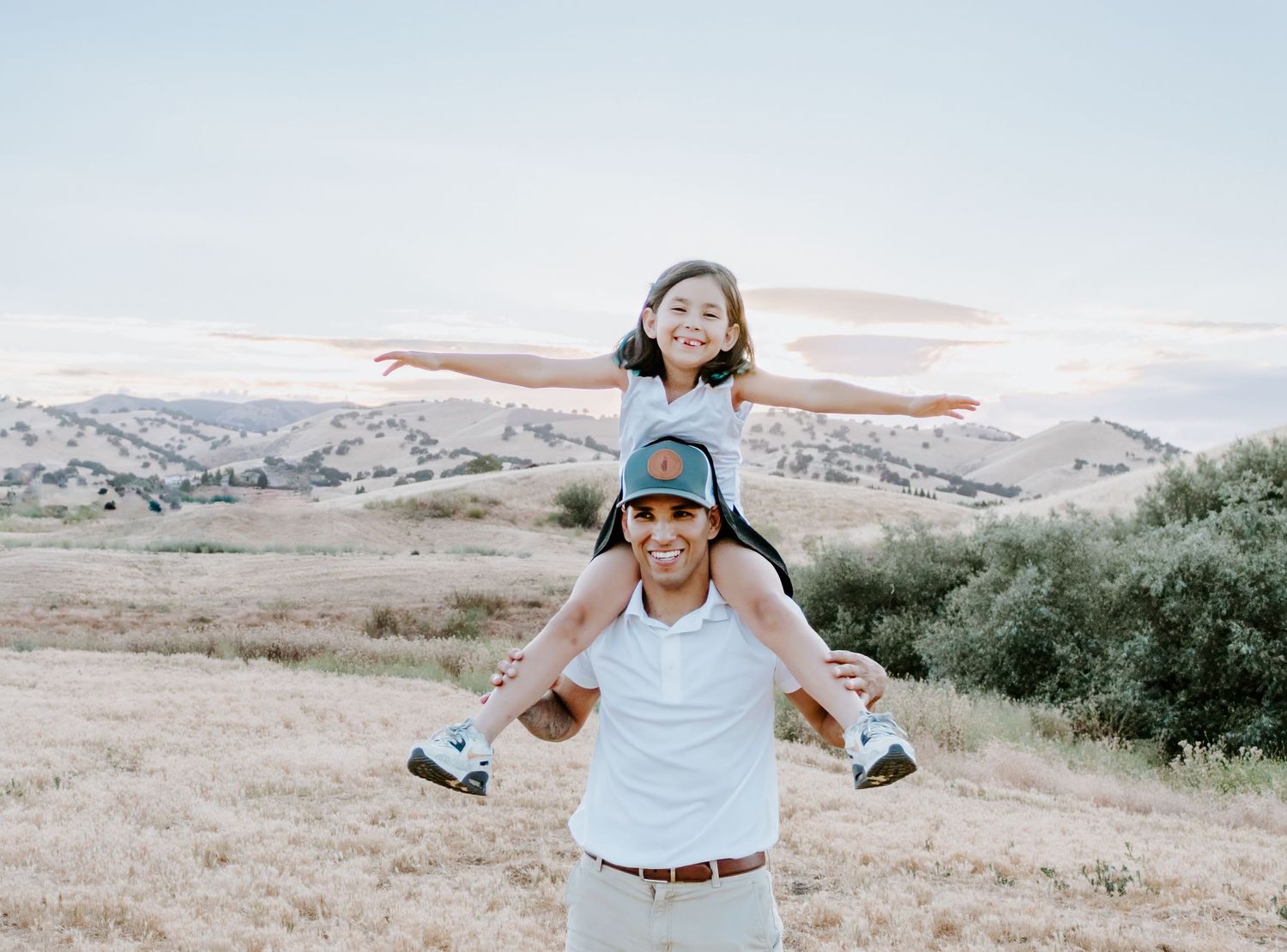 A joyful piggyback ride in a scenic mountain landscape during golden hour.