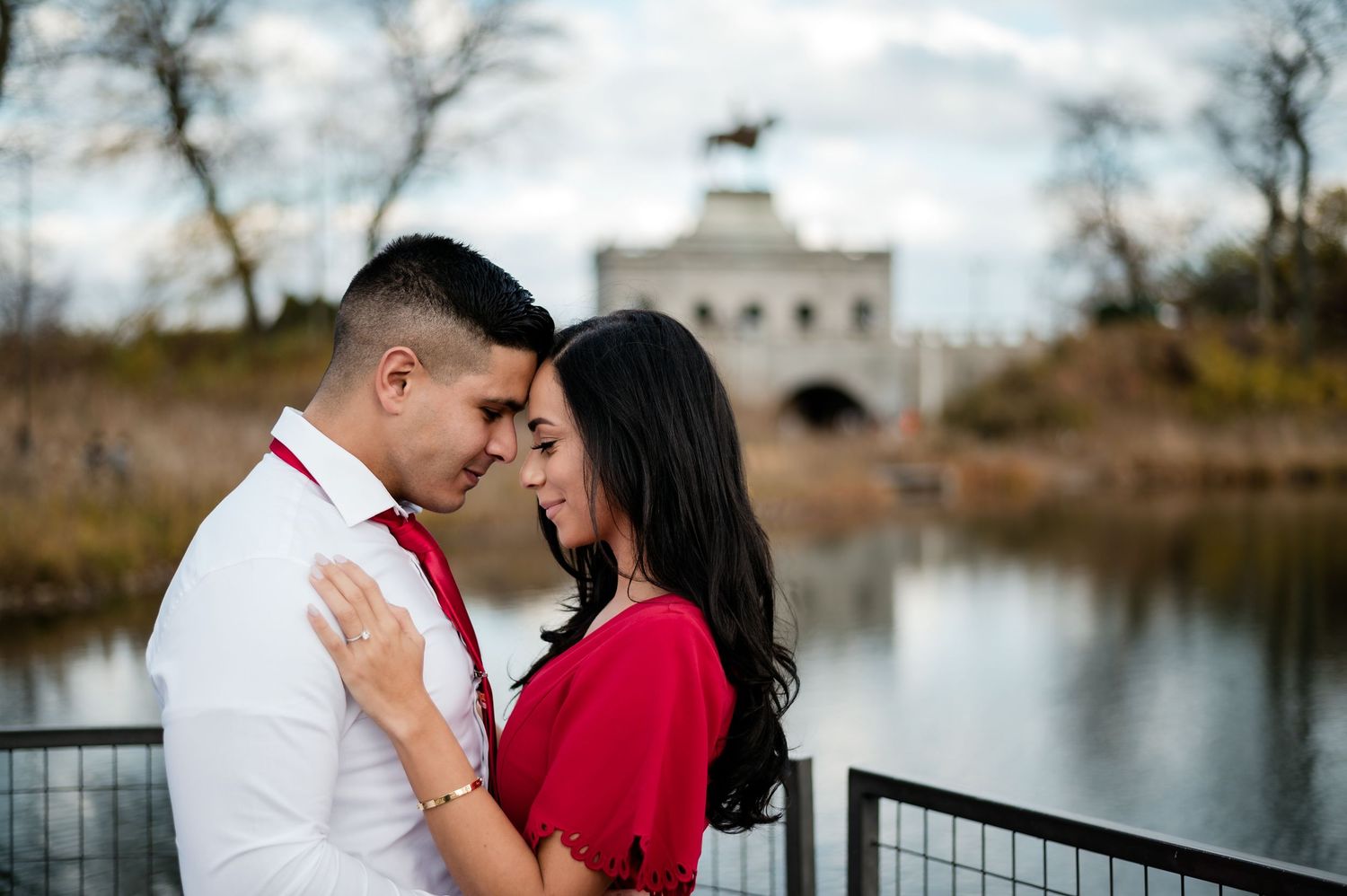 A couple sits together in a stone tunnel with arched walls and soft lighting creating a romantic atmosphere.