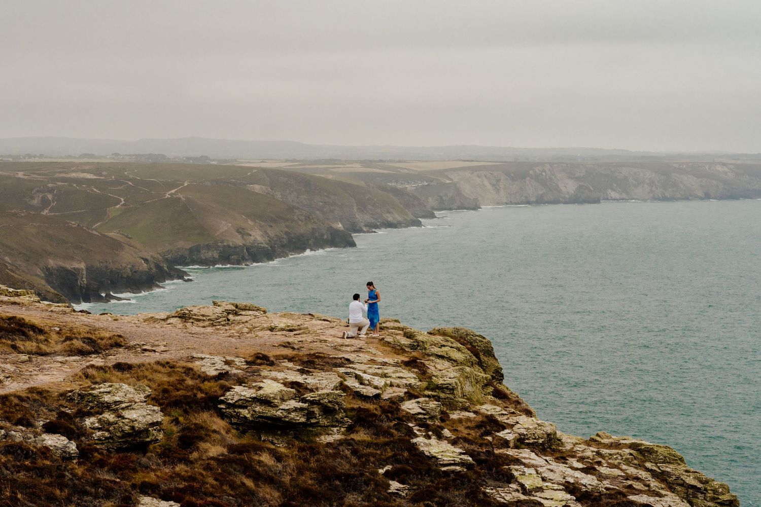 man proposing to partner at the viewpoint at st agnes head overlooking chapel porth beach.