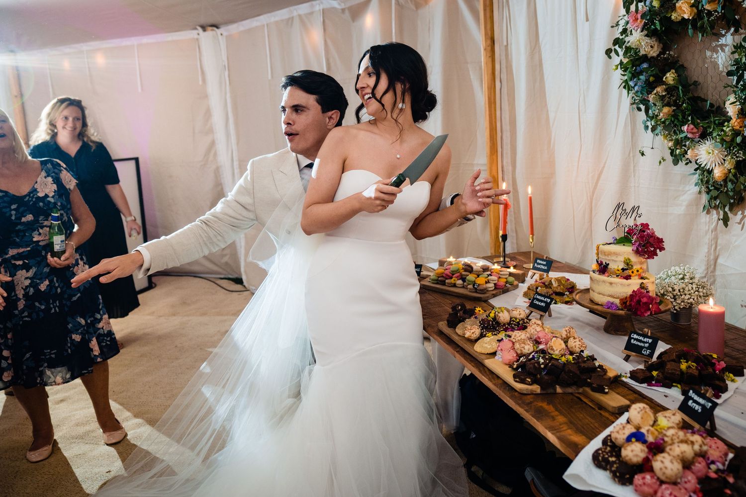 Bride and groom share a romantic first dance near a rustic dessert table at their elegant wedding reception.