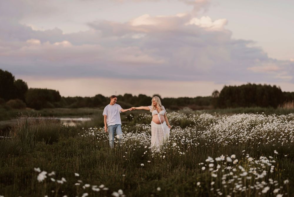 Five sequential photos show people dancing together in a sunset meadow filled with white wildflowers on a cloudy evening.