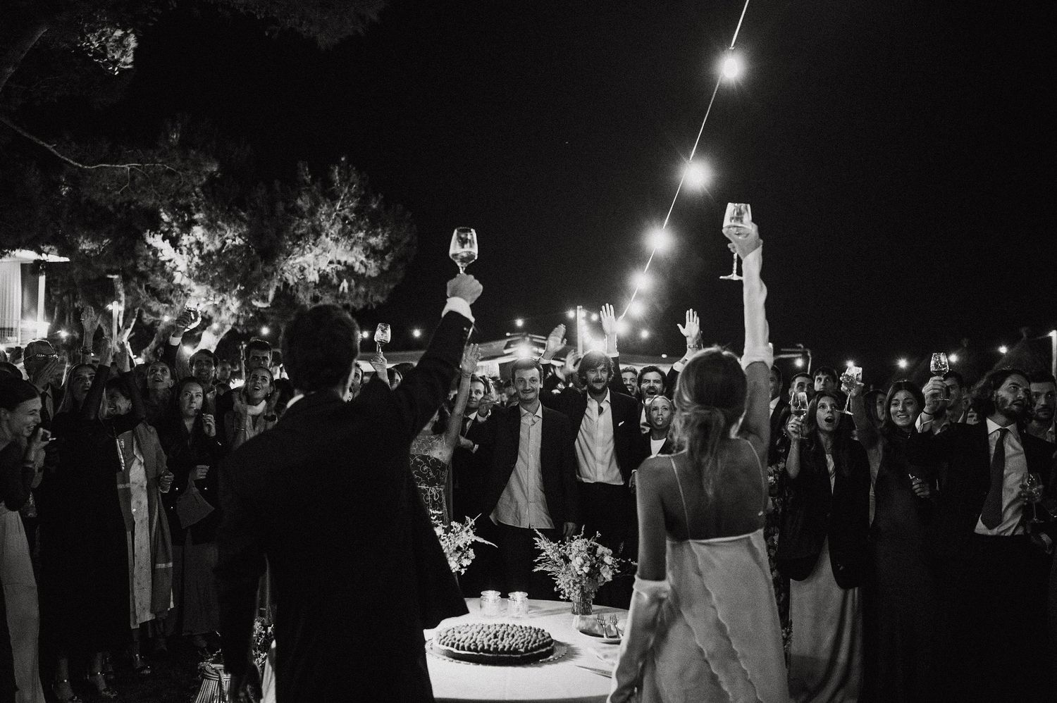 A montage of black and white wedding reception photos showing dancing, dining and celebration at night.