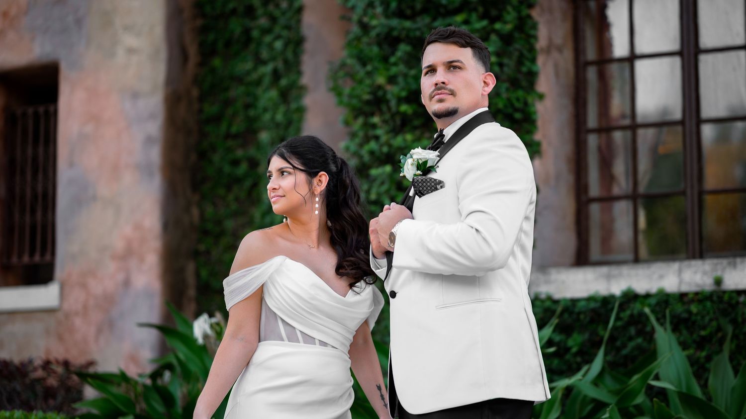 Luxury wedding photographers in Florida captured this bride and groom in front of the grass wall at the Howey Mansion during their wedding.