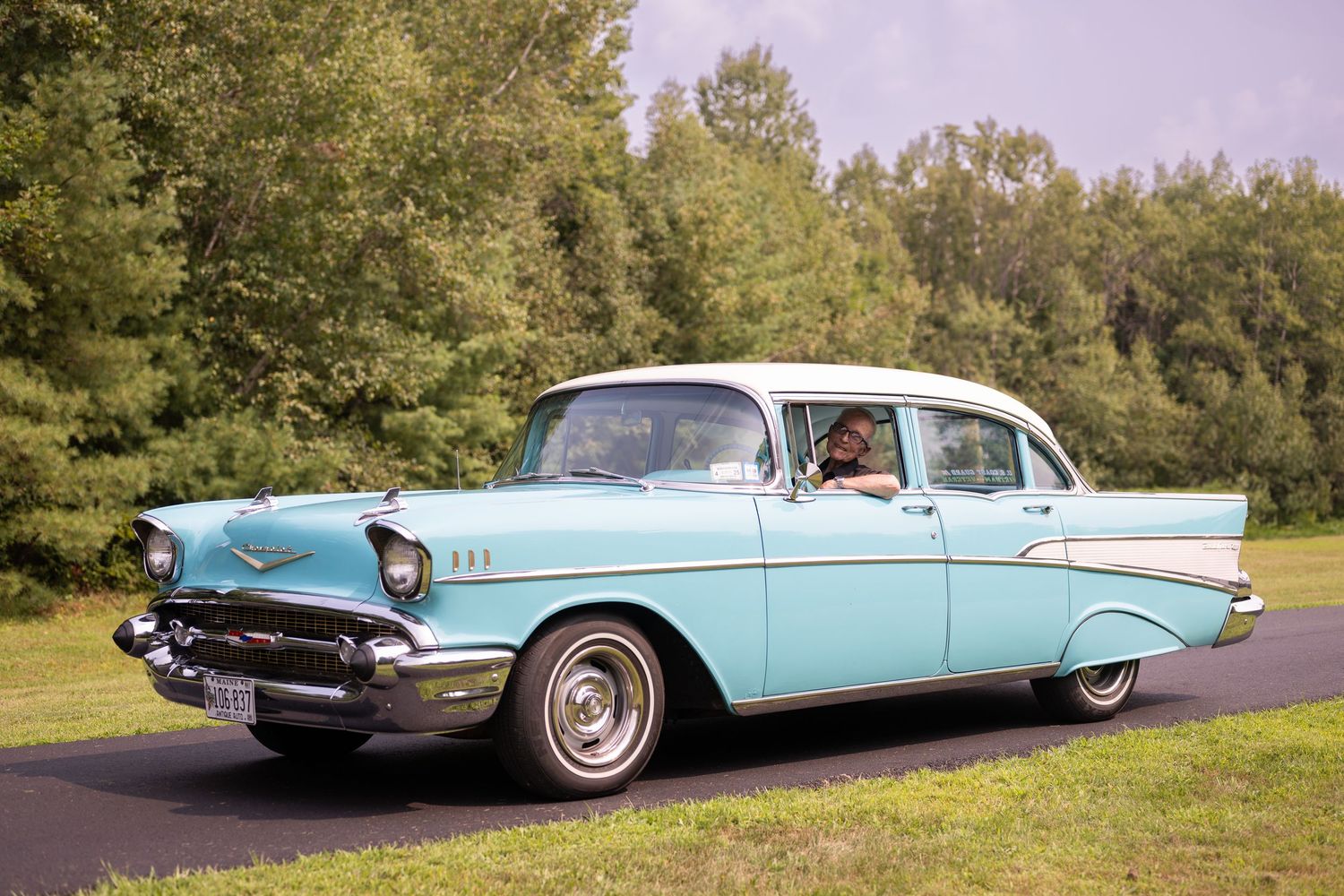Classic turquoise Chevrolet cars lined up on display at an outdoor event.