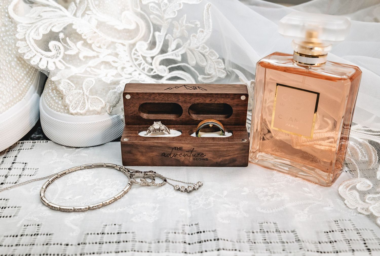 Vintage copper trinket boxes arranged with lace and tea cups on a rustic white wood surface.