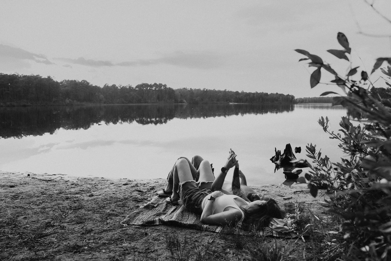 Seven black and white vintage photographs showing a person lying down in various outdoor nature settings.