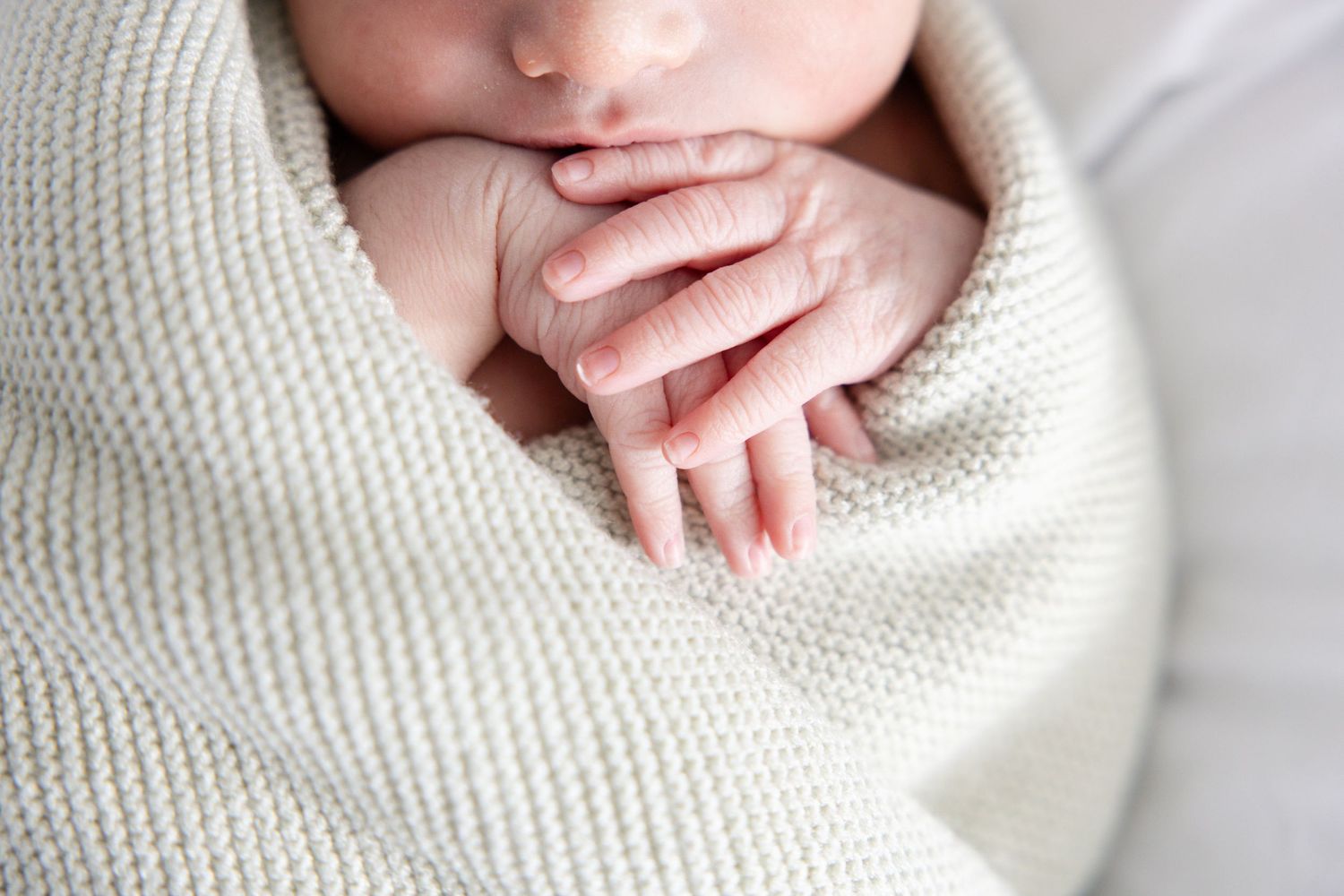 A close-up sequence showing delicate baby toes being gently touched and held by adult hands.