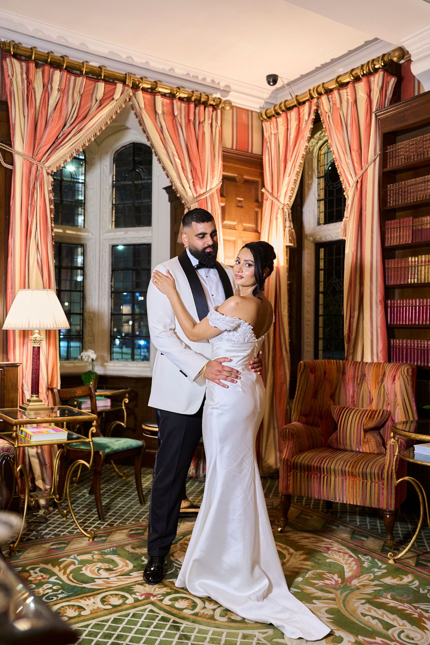 An elegant ballroom with striped curtains and ornate carpeting provides a romantic setting.