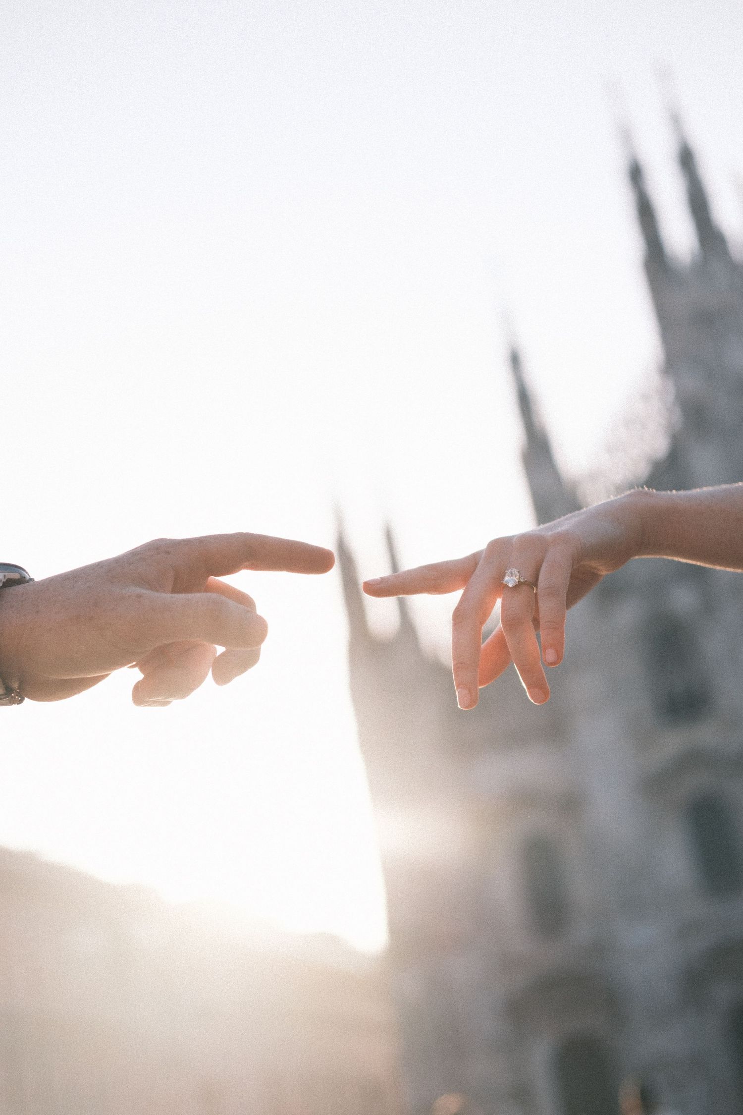 Man proposing on one knee to woman in front of Milan Cathedral Duomo di Milano in Italy.