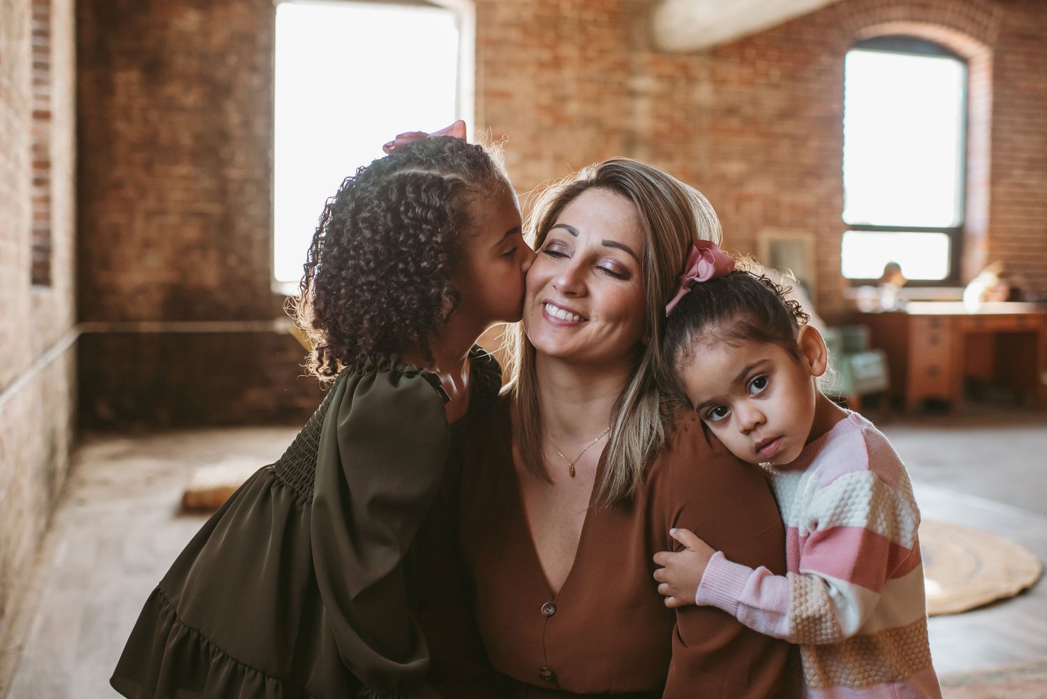 Mom of two receiving a little kiss from her oldest daughter at a photoshoot in Newport News, Virginia.