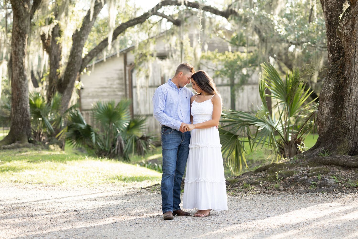 Romantic outdoor portrait in front of Spanish moss draped trees by a lake.