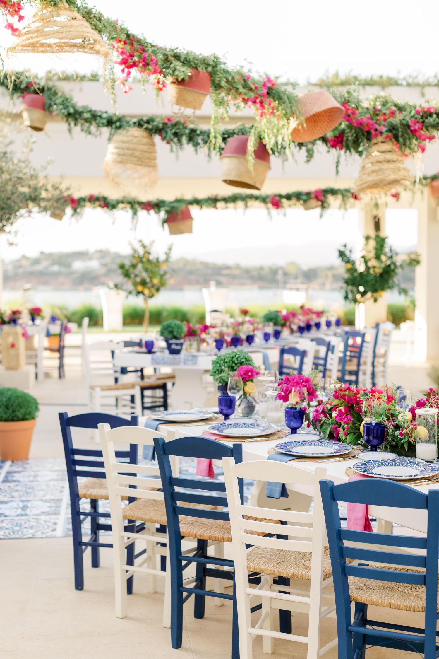 Classical white bust centerpiece surrounded by pink and purple flowers on elegant table setting.