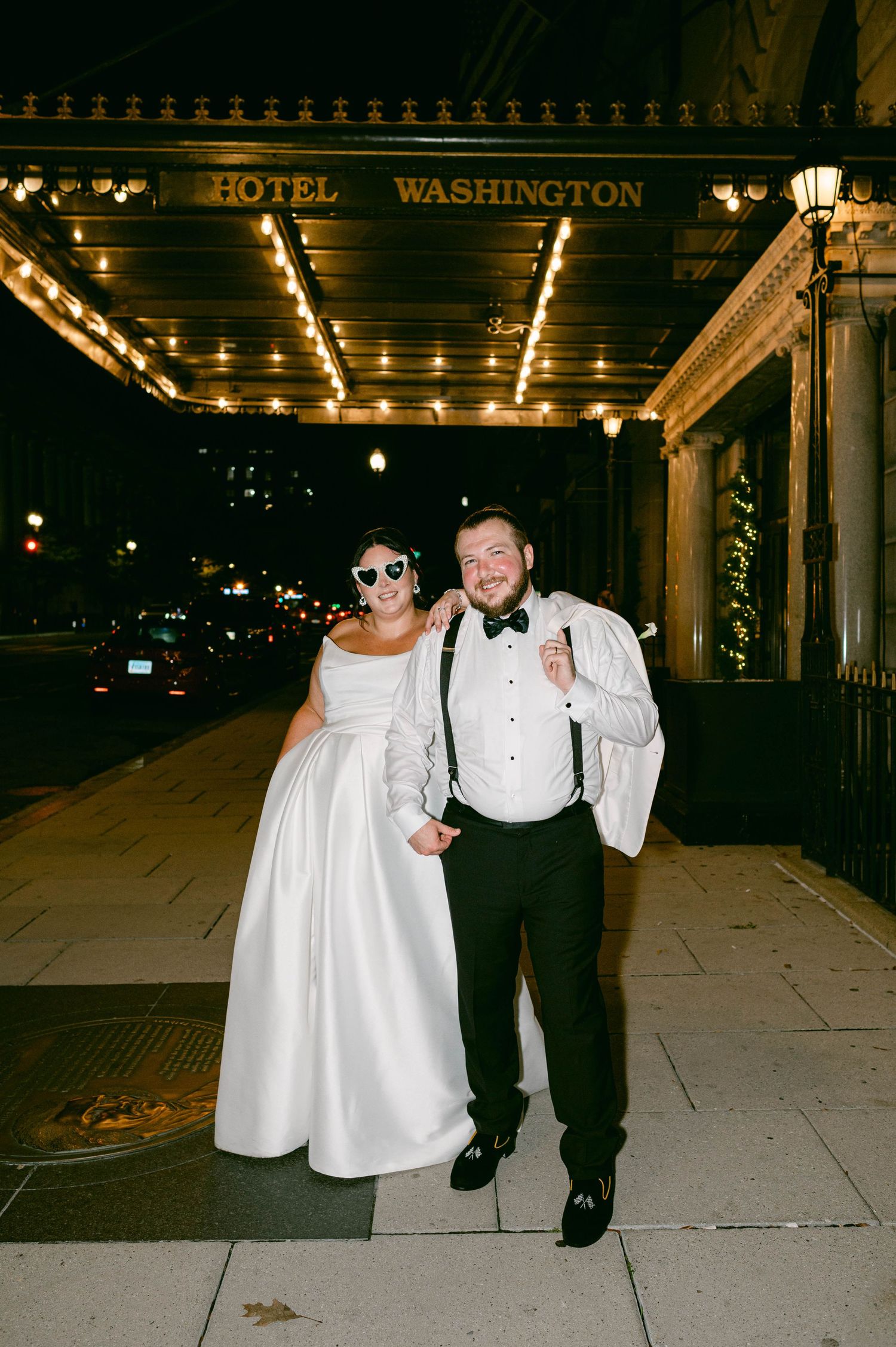 Nighttime wedding photo featuring formal attire and stylish sunglasses.