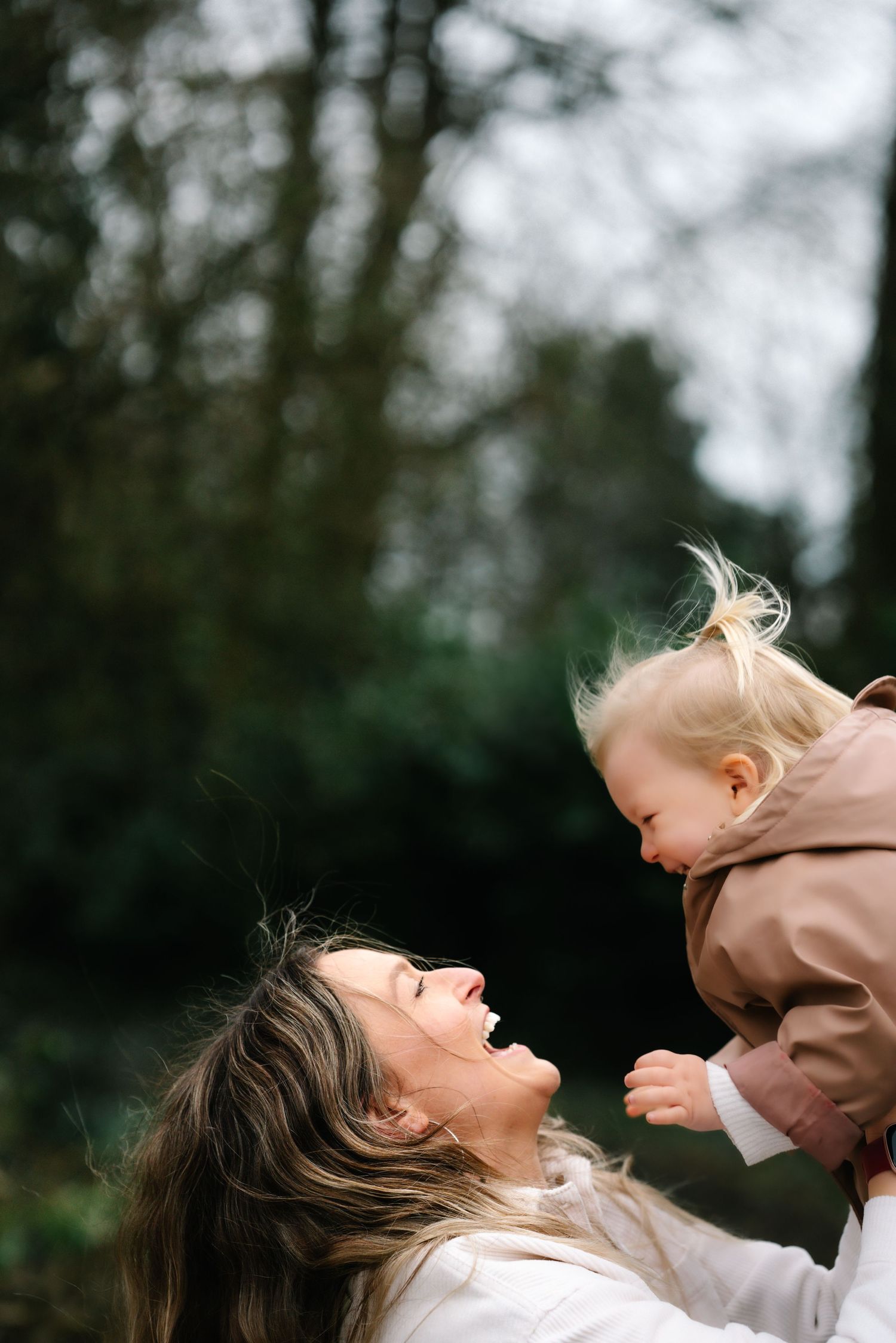 A joyful candid moment between parent and baby playing outdoors.