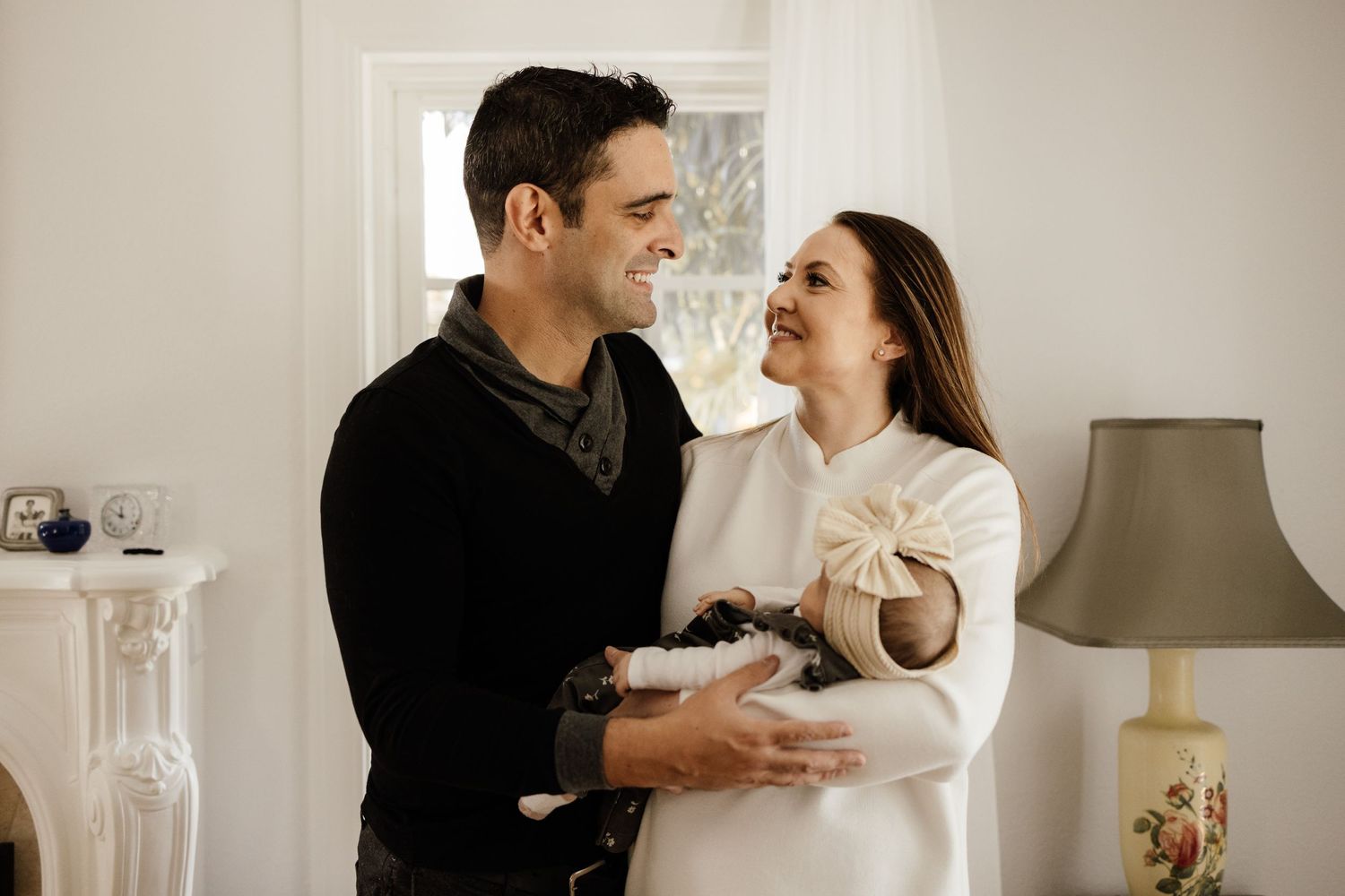 Mother and father look at each other during a relaxed in-home newborn session in San Jose with Bay Area Newborn Photographer Cindy Tucey
