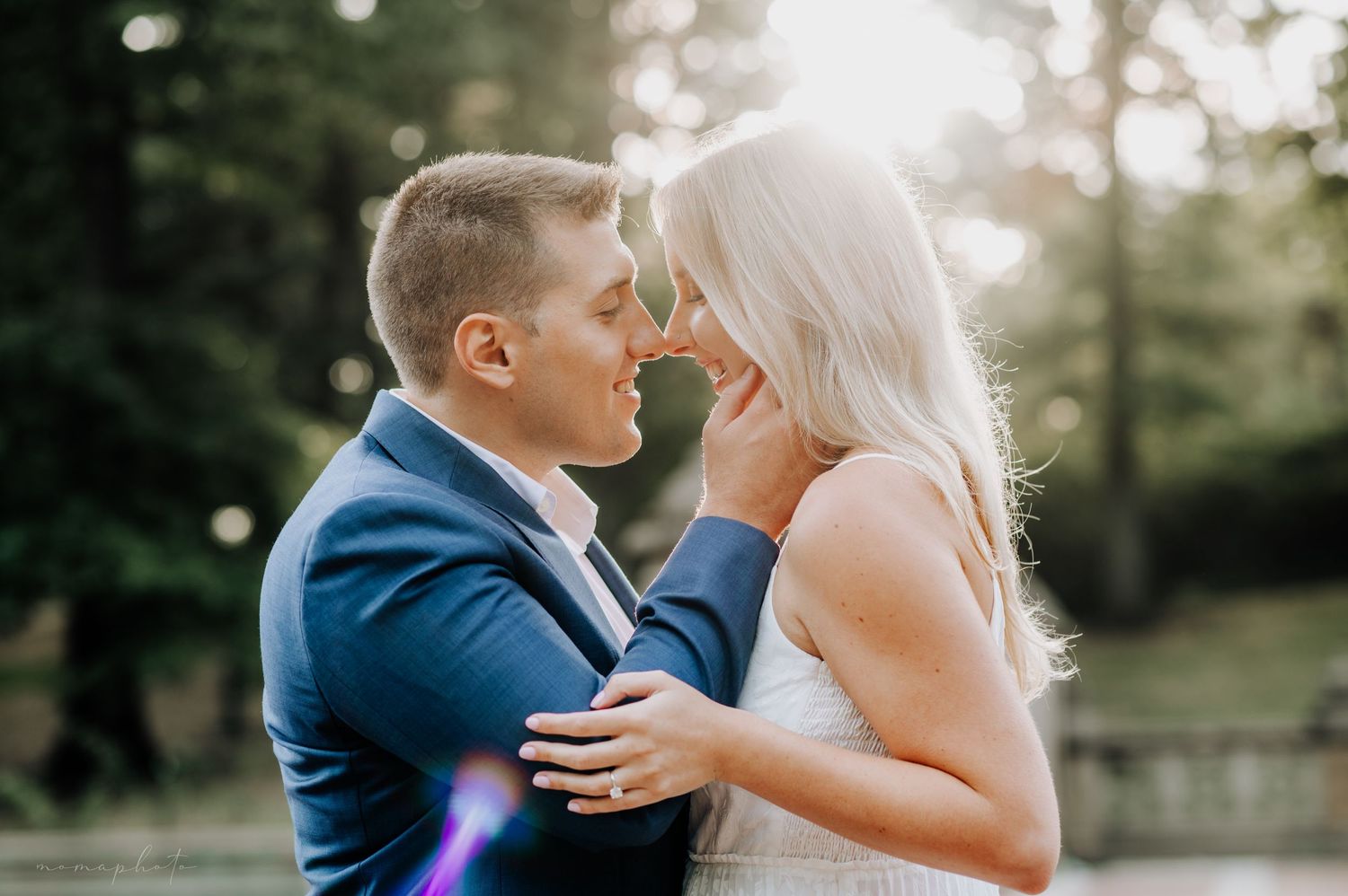Romantic wedding couple embraces in a sunlit garden setting with dreamy bokeh lighting effects.