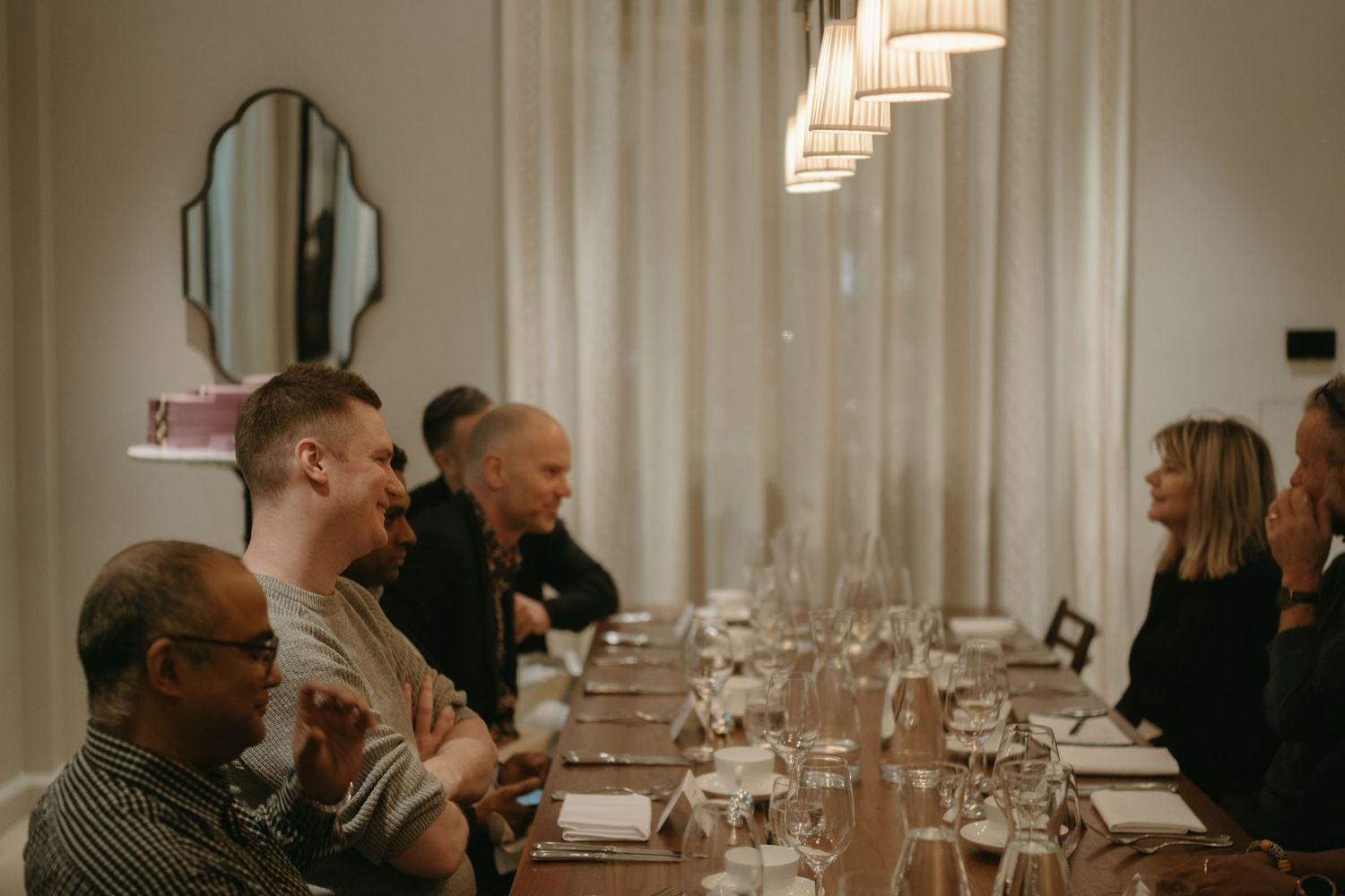 group of people sitting around the table sharing lunch at Villa Dagmar Stockholm while being captured by event photographer in Stockholm
